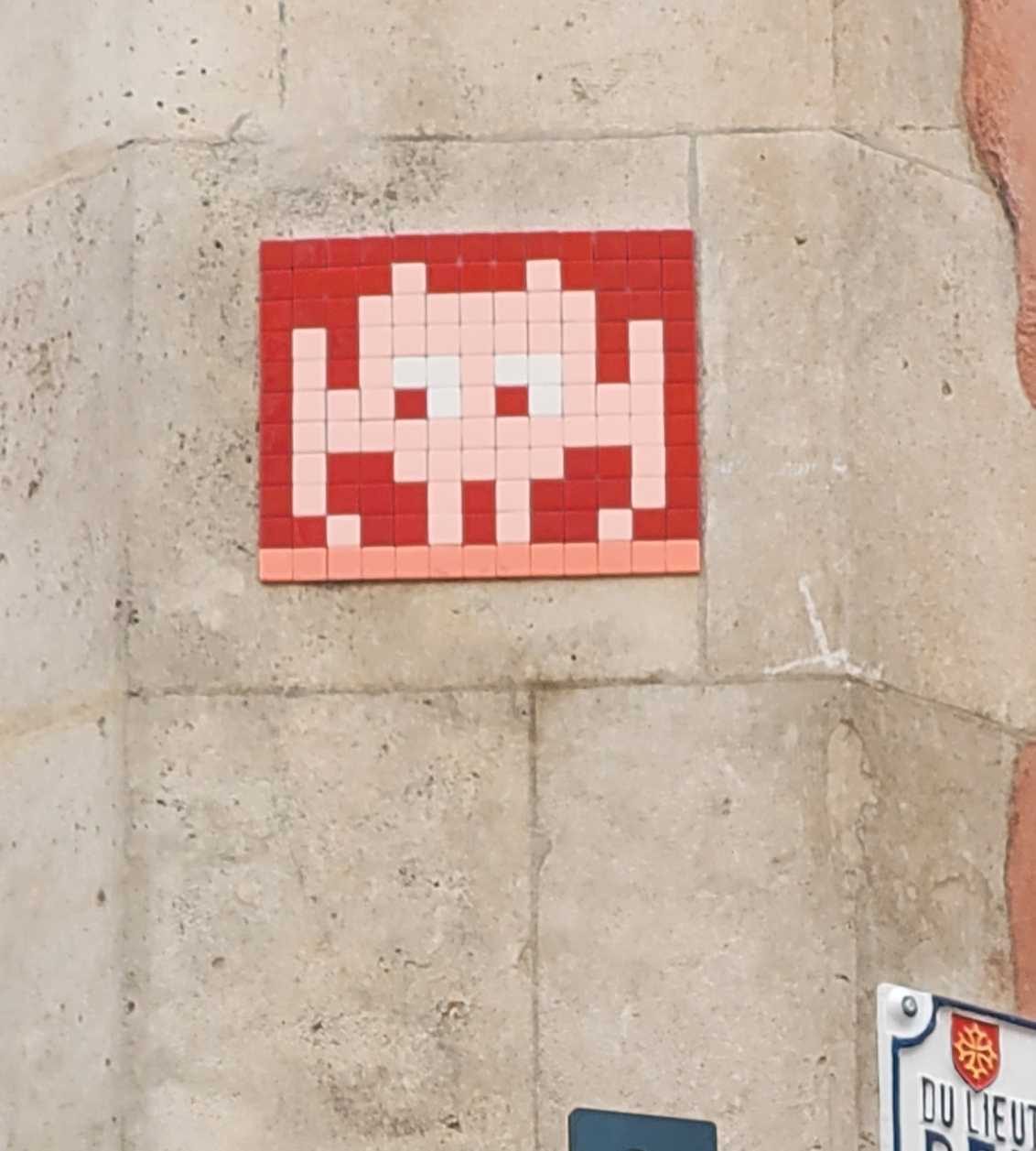 TLS_07, Crimson Alien on Red — Street art by Invader in Toulouse