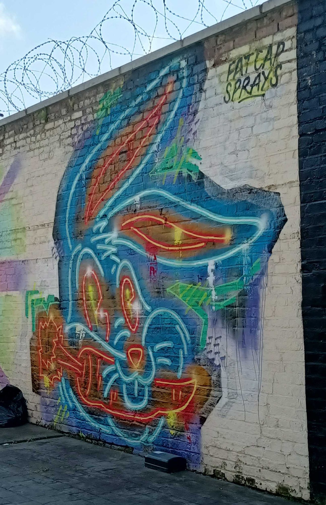 Tête cartoon au néon bleu — Street art de Fat Cap Sprays à London