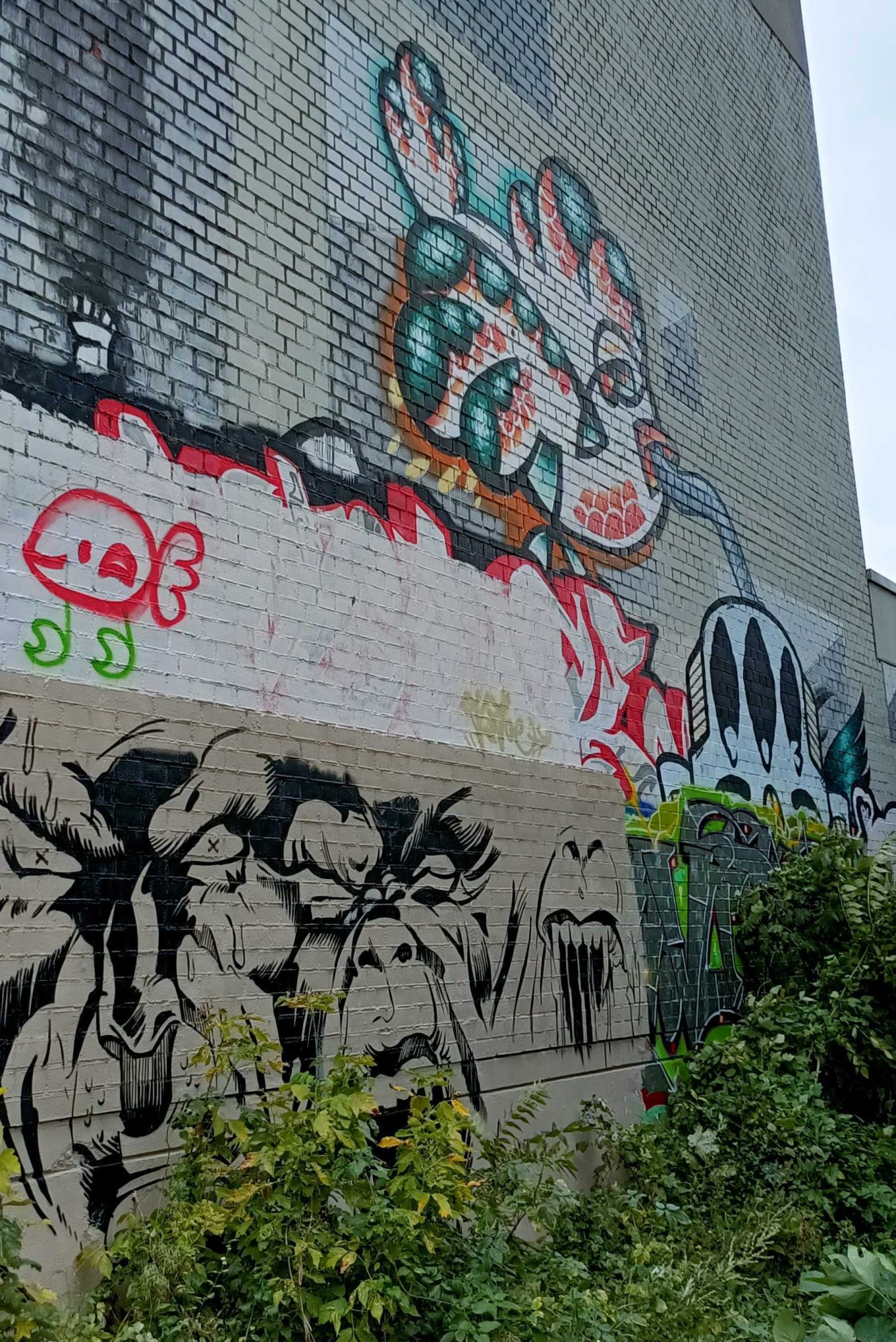 Créature verte et frise de grimaces — Street art à Berlin