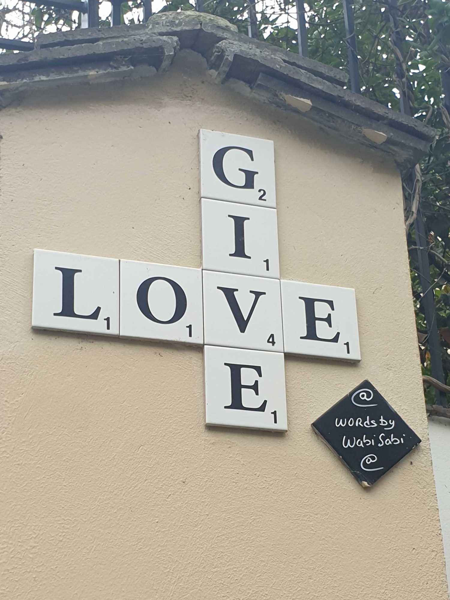 Give Love en jetons de Scrabble — Street art à Paris