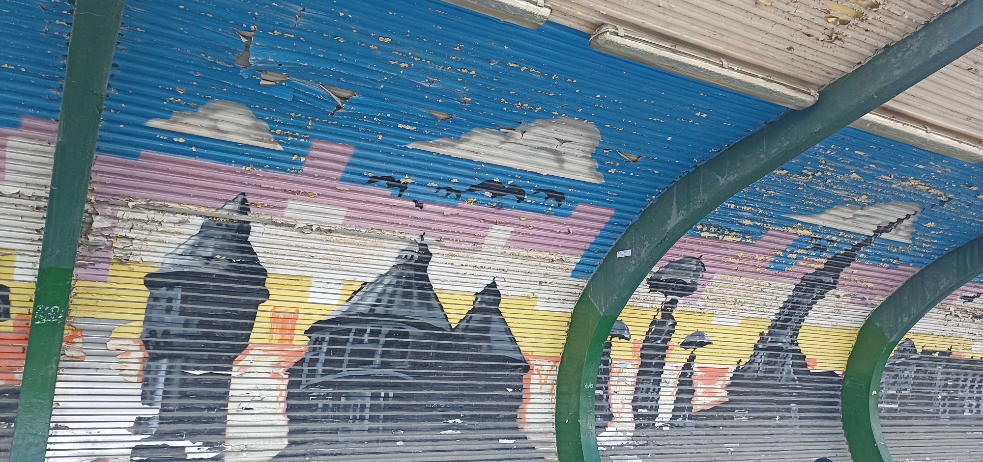 Black roofs under a striped sky — Street art in Budapest