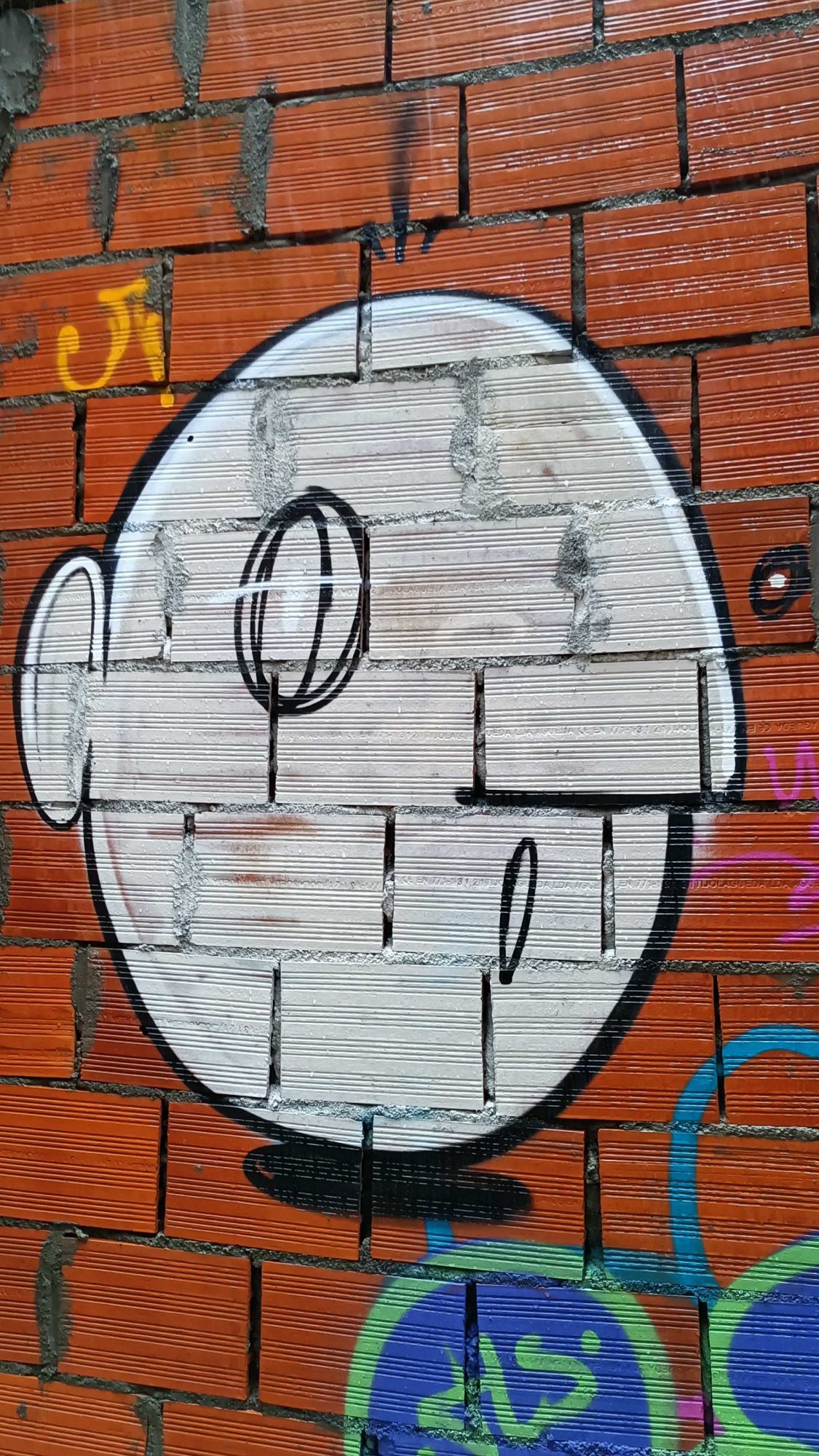 Visage blanc sur briques rouges — Street art à Porto