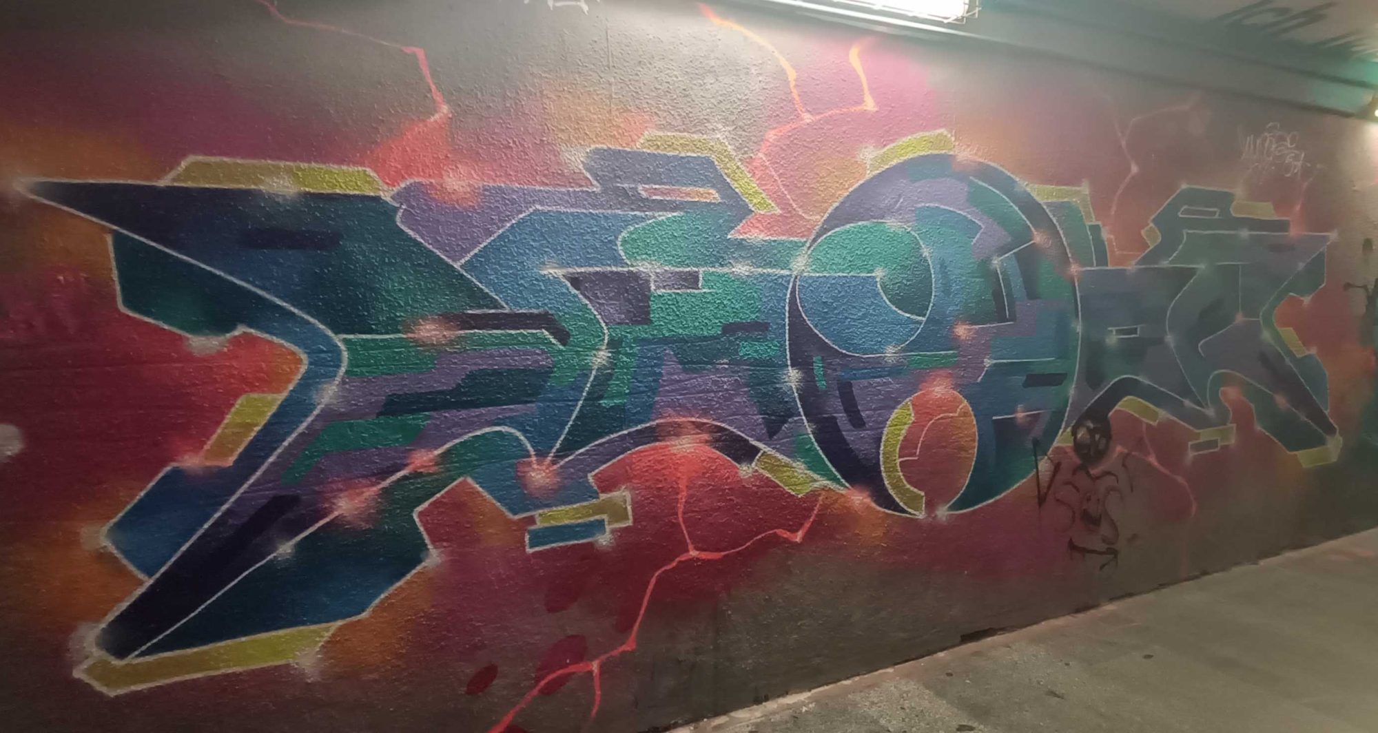 Pièce wildstyle bleue et verte sur fond rouge — Street art à Prague