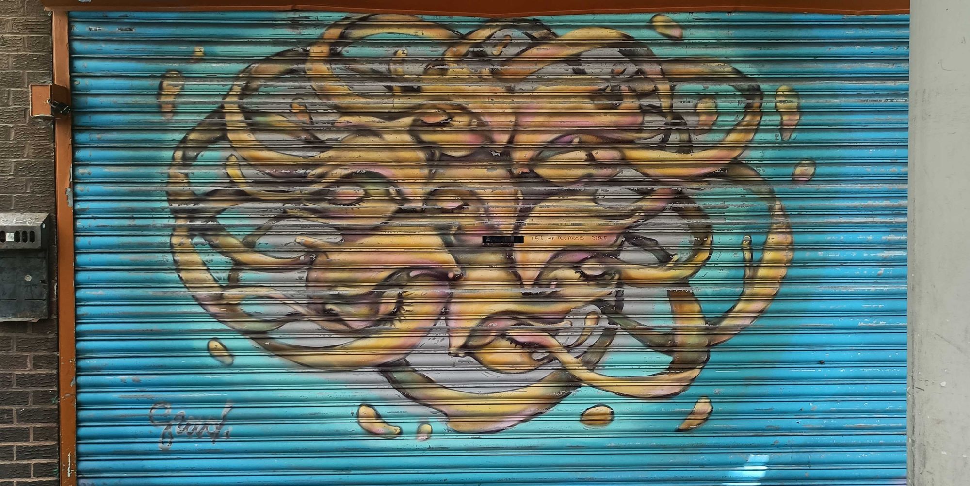 Ribbon faces on a turquoise shutter — Street art in London