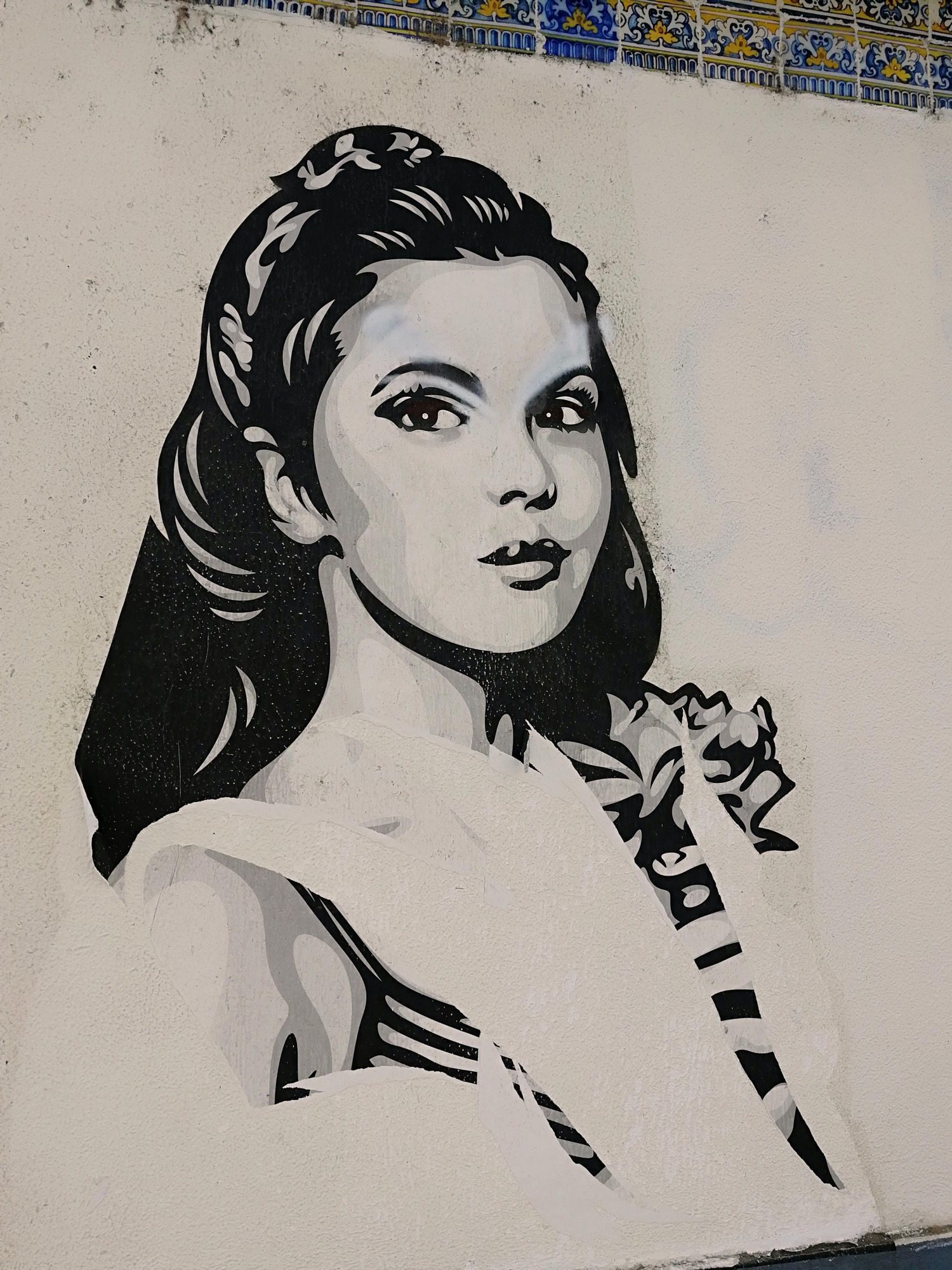 Stencilled Woman beneath the Azulejo Frieze — Street art in Lisboa