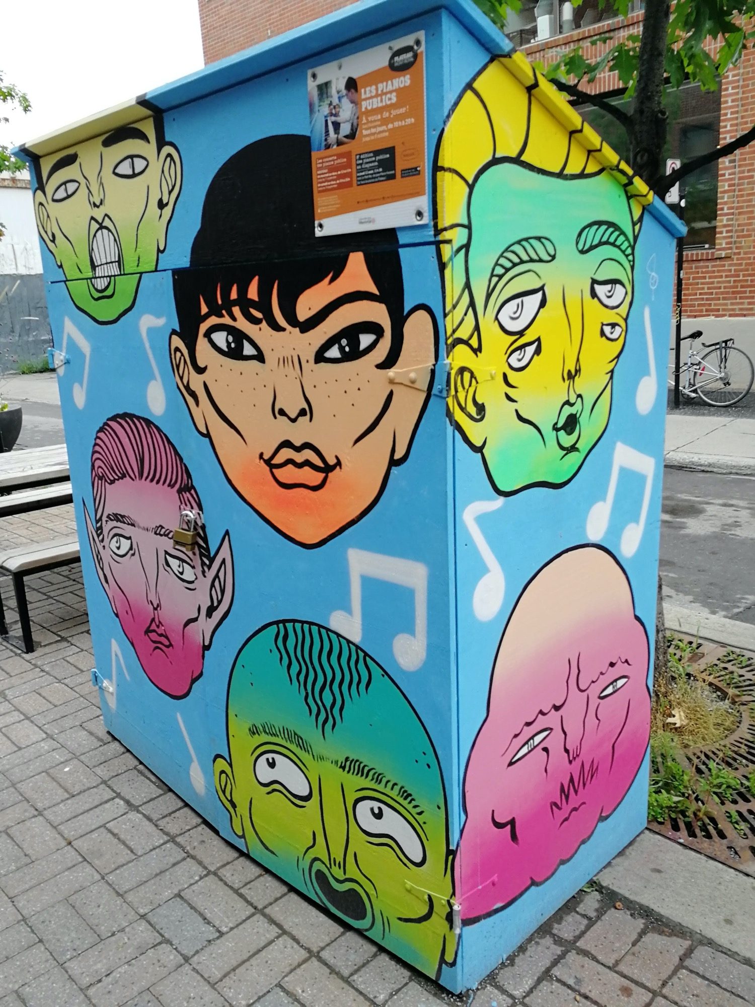 Boîtier aux visages et notes de musique — Street art à Montréal