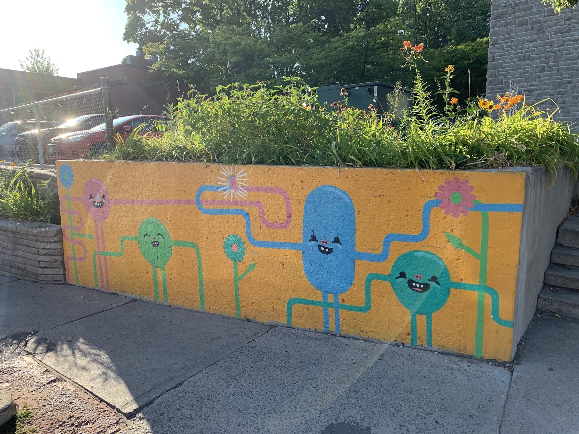 Personnages ronds souriants sur bac orange — Street art à Ottawa