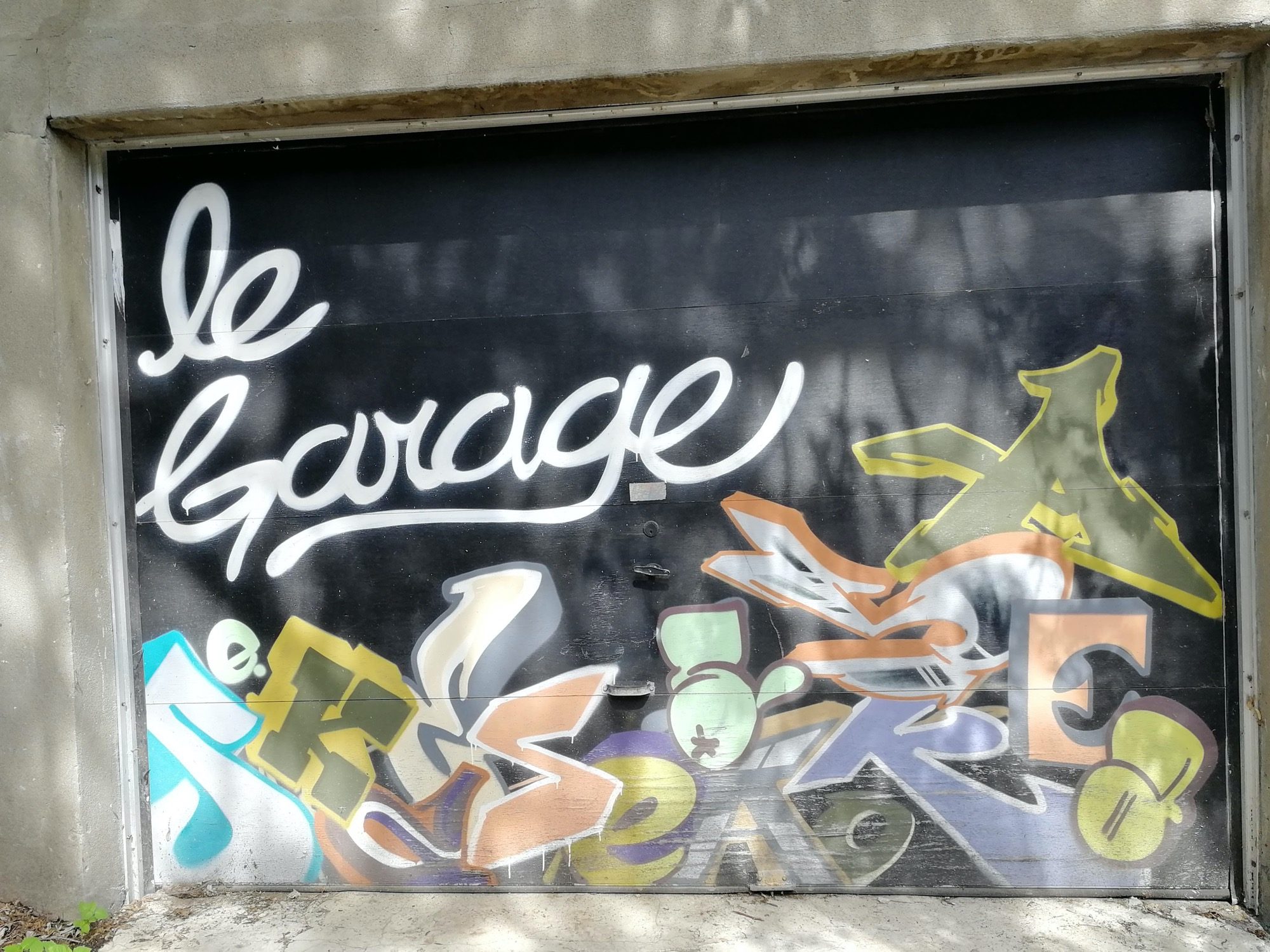 le Garage, en cursive blanche — Street art à Montréal