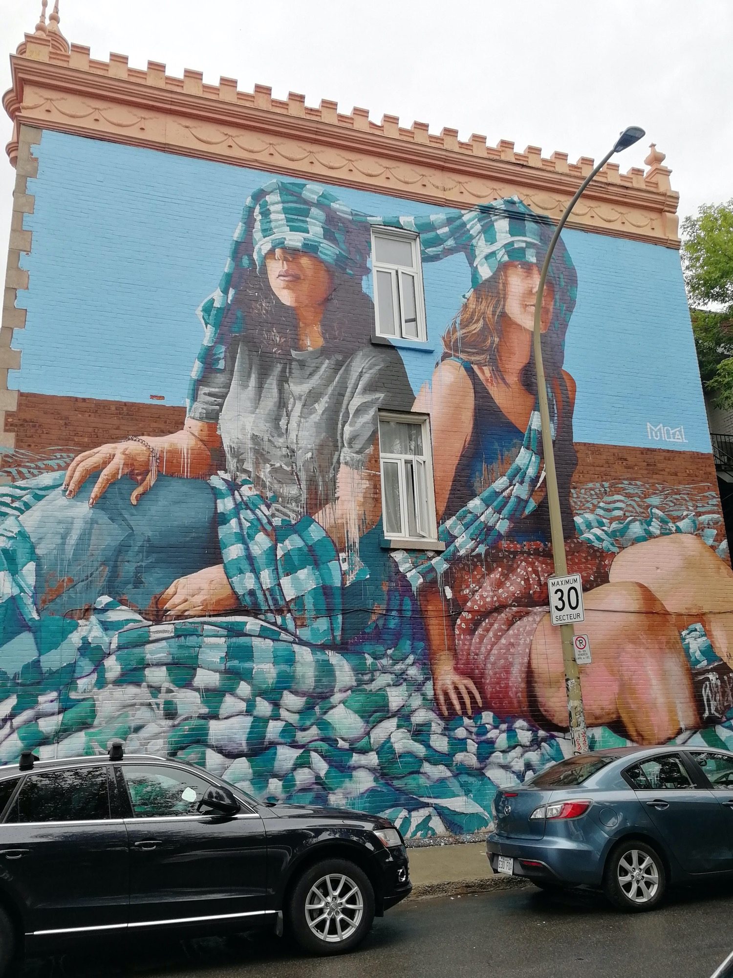 The Two Women Under the Checked Blanket — Street art by Fintan Magee in Montréal