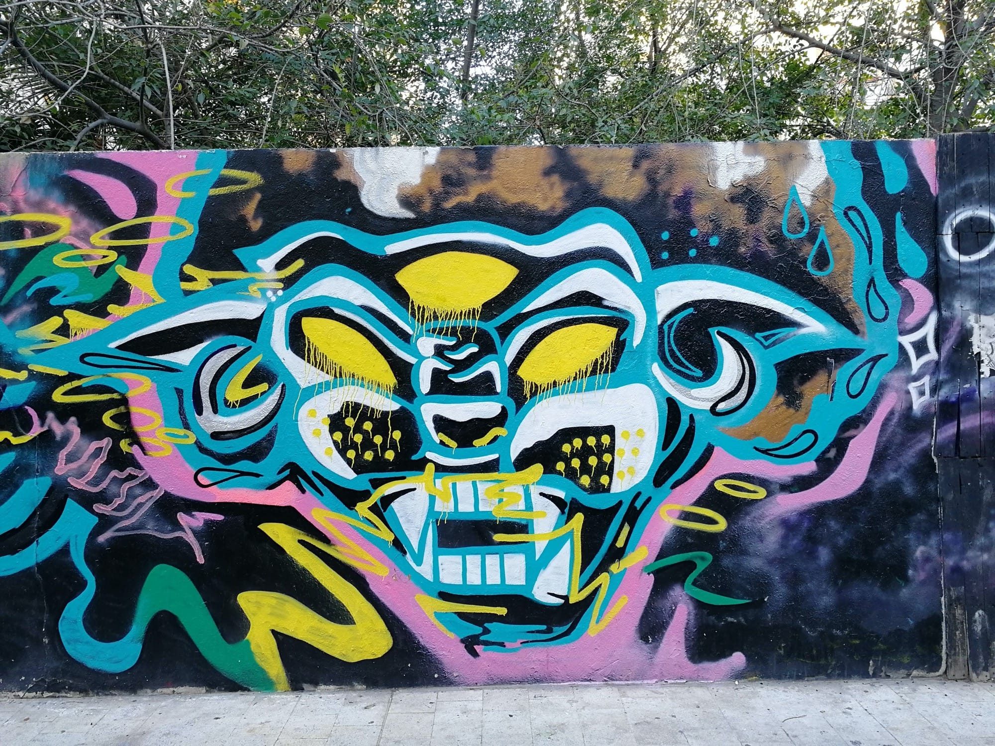 Grimacing Yellow Demon on Black Background — Street art in València
