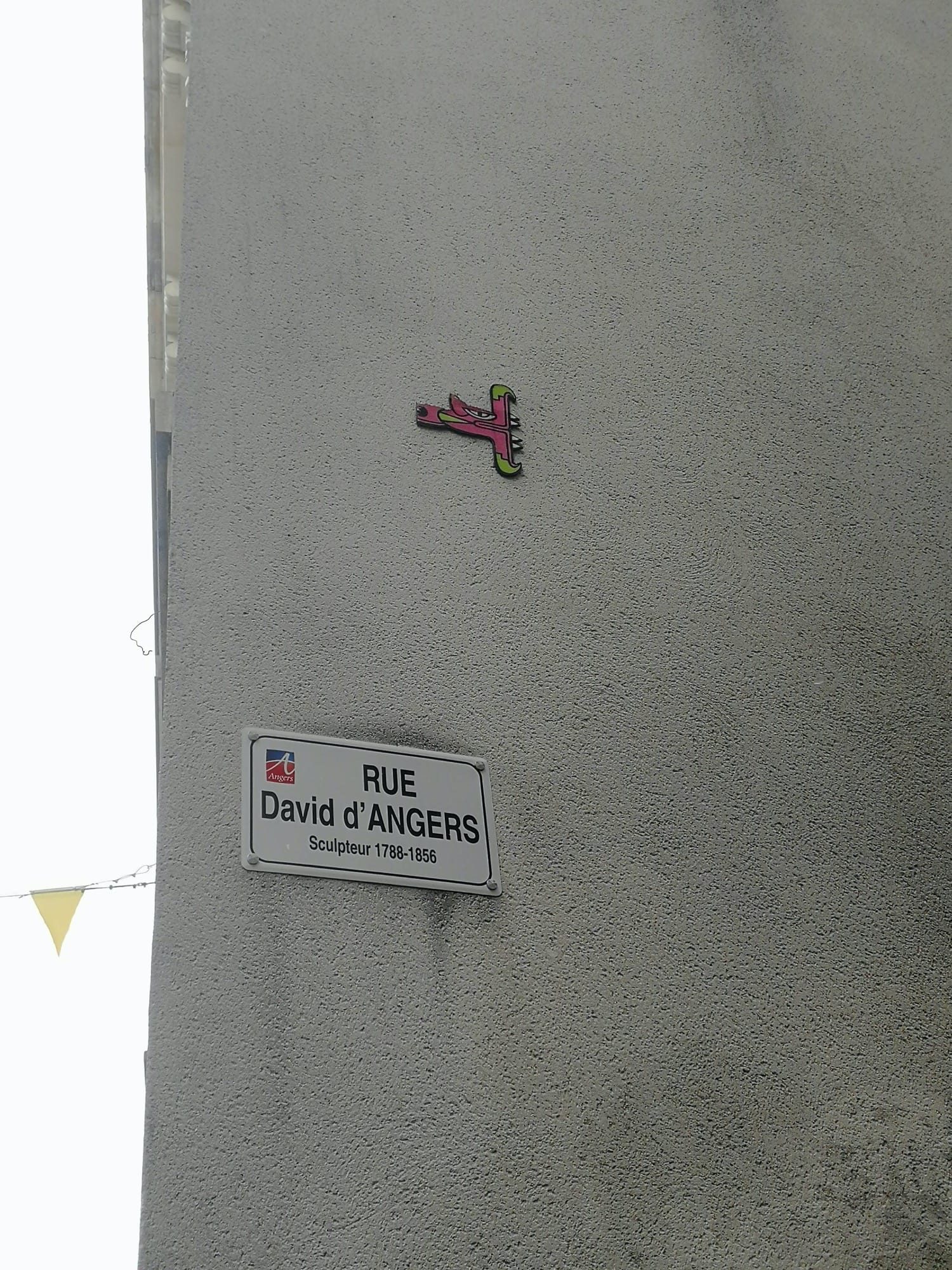 Sticker rose au-dessus de la plaque de rue — Street art de Oré à Angers