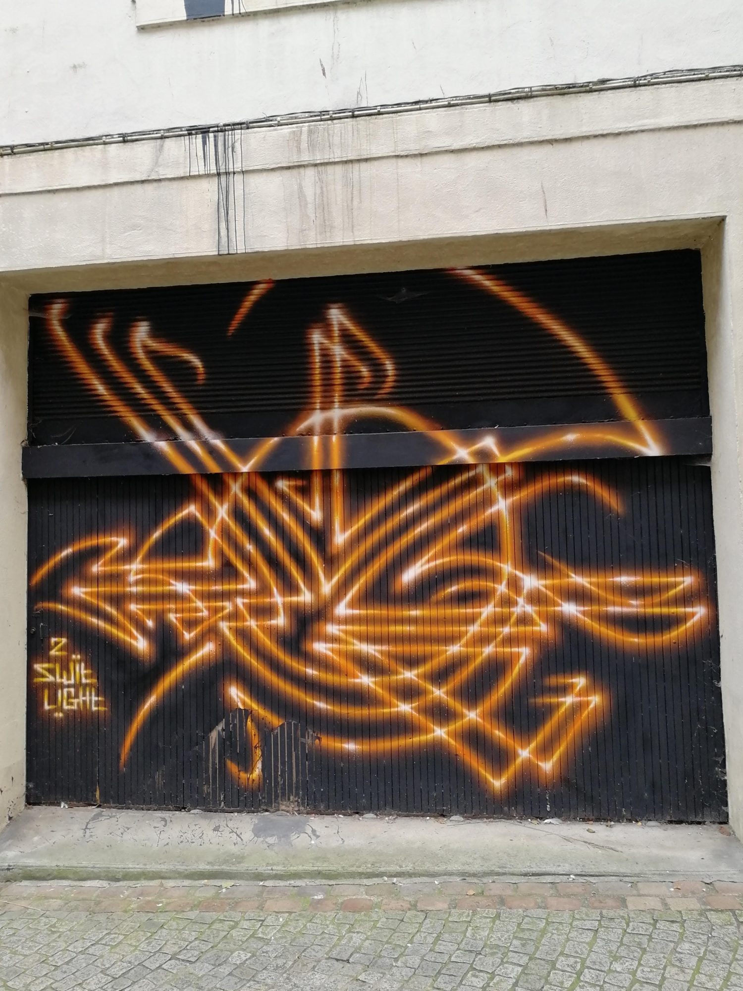 Glowing Orange Tag on Black Background — Street art in Morlaix