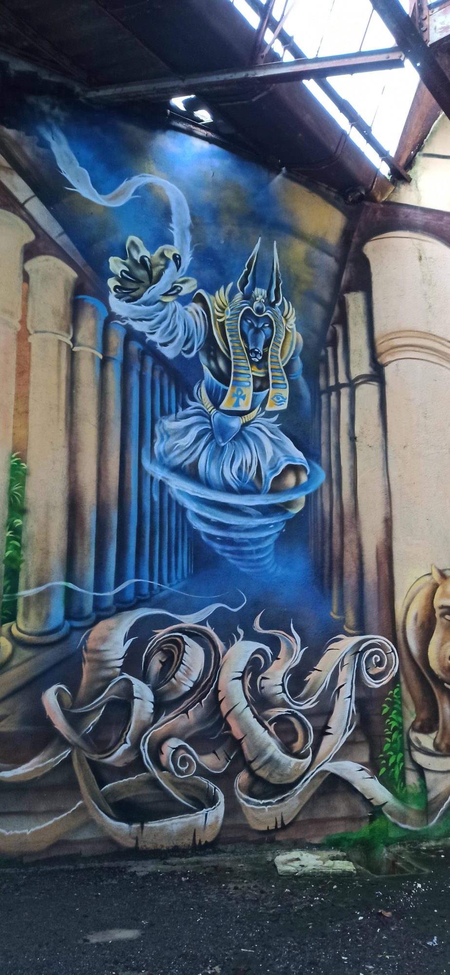 Génie bleu tourbillonnant entre colonnes antiques — Street art à Lorient
