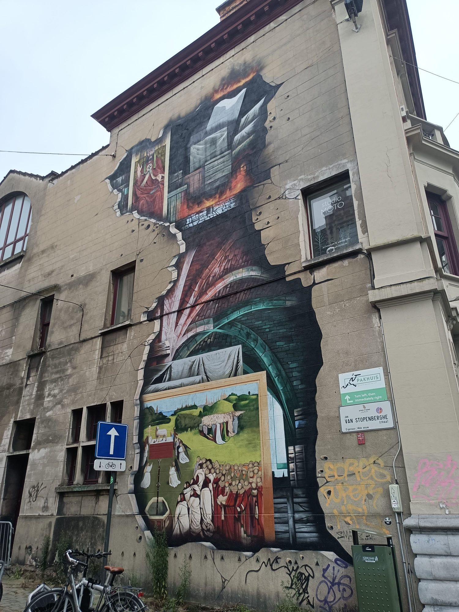 The facade torn open onto a throat — Street art in Gent