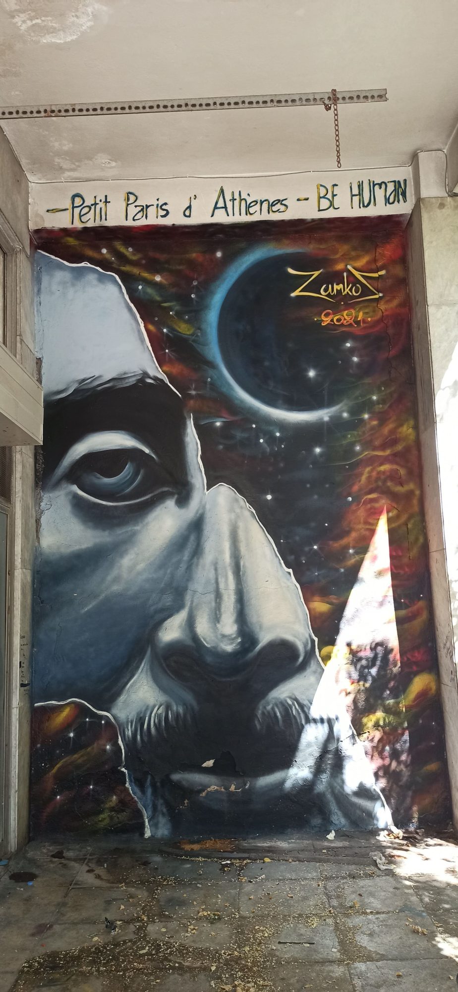 Be Human, Face Beneath the Eclipse — Street art in Athina