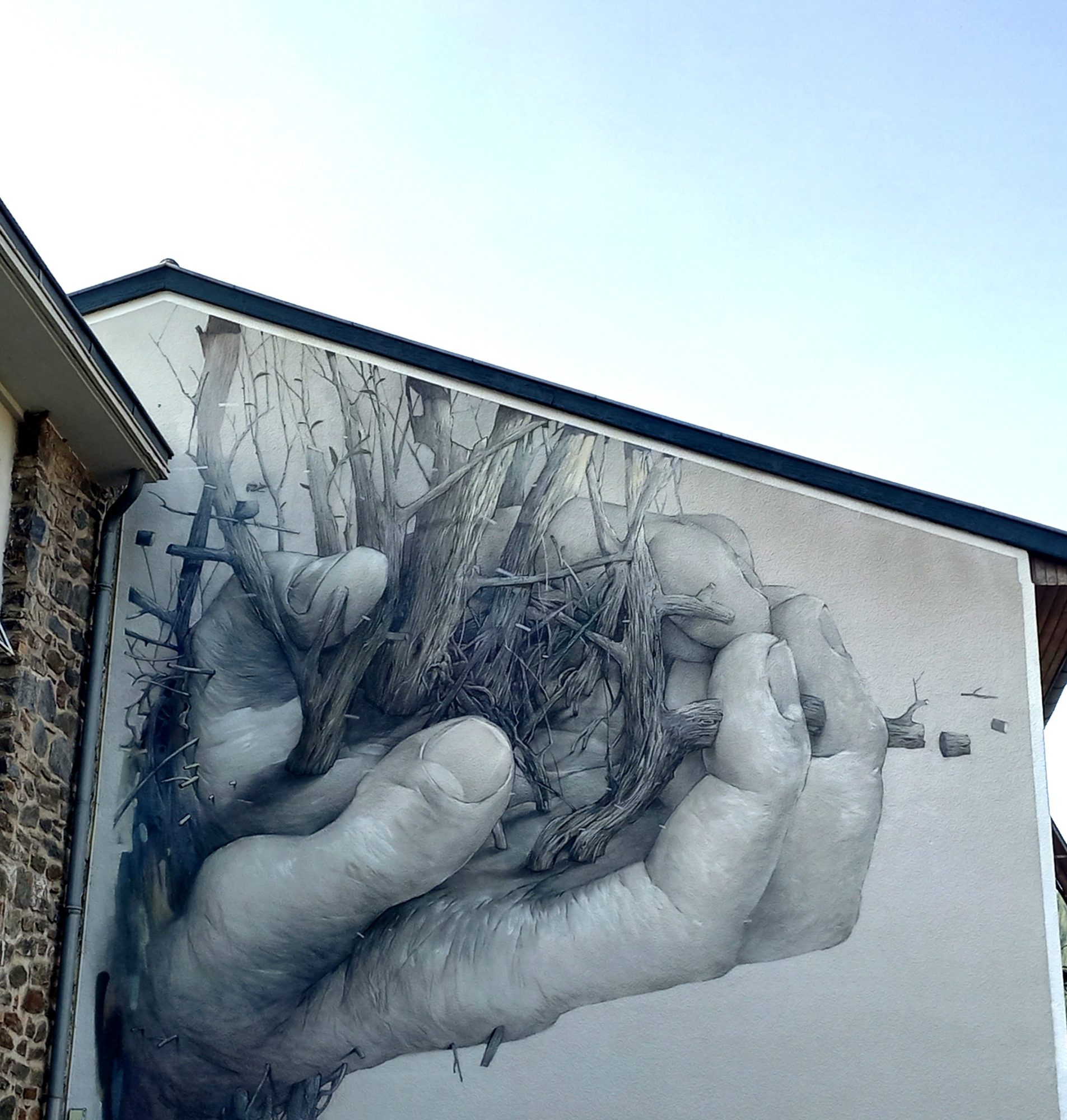 Hands Holding a Nest — Street art by Bom.k in Viviez