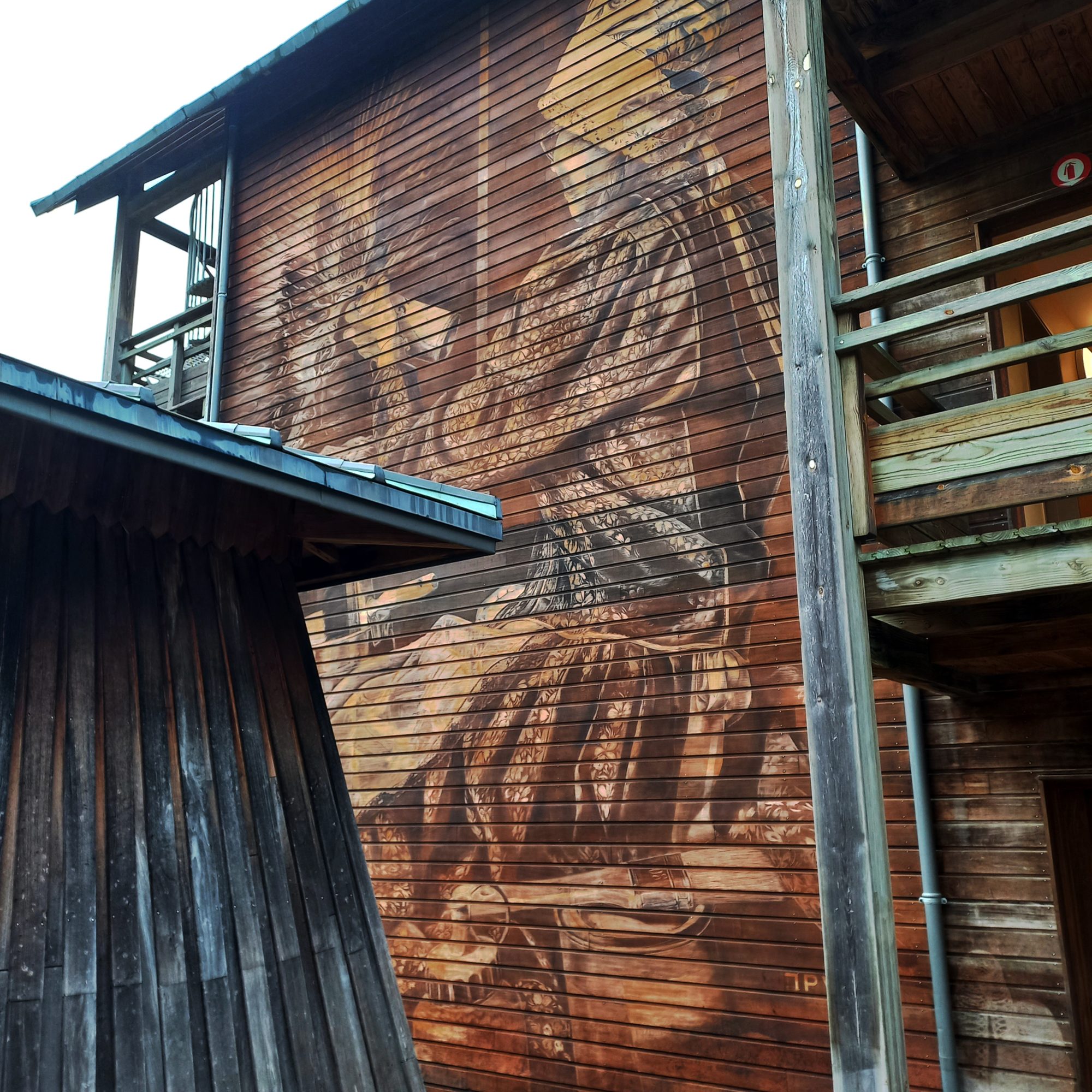 Silhouette peinte sur le bardage — Street art de LPVDA à Cransac-les-Thermes