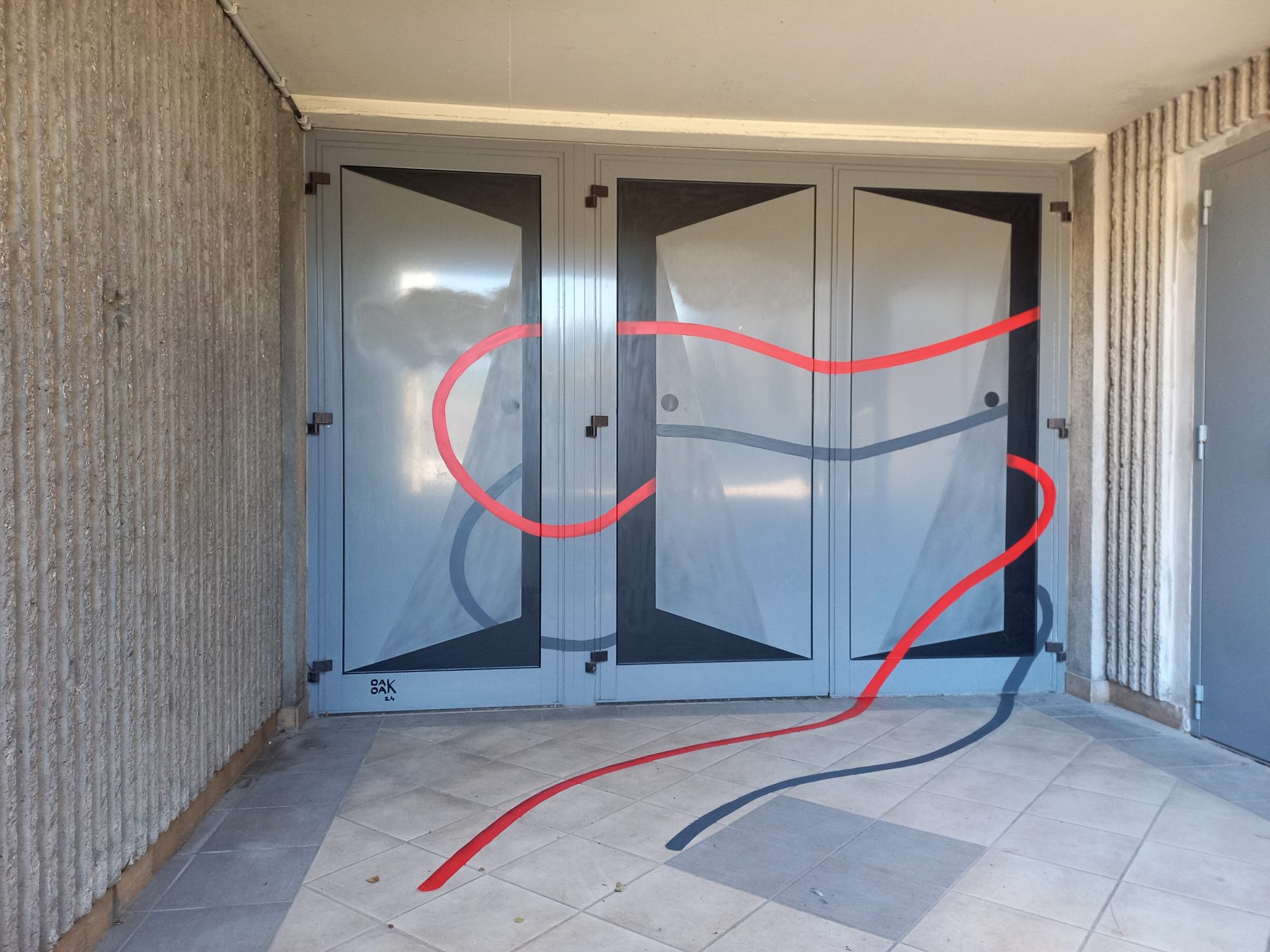 Two ribbons across the glass doors — Street art by OakOak in Decazeville
