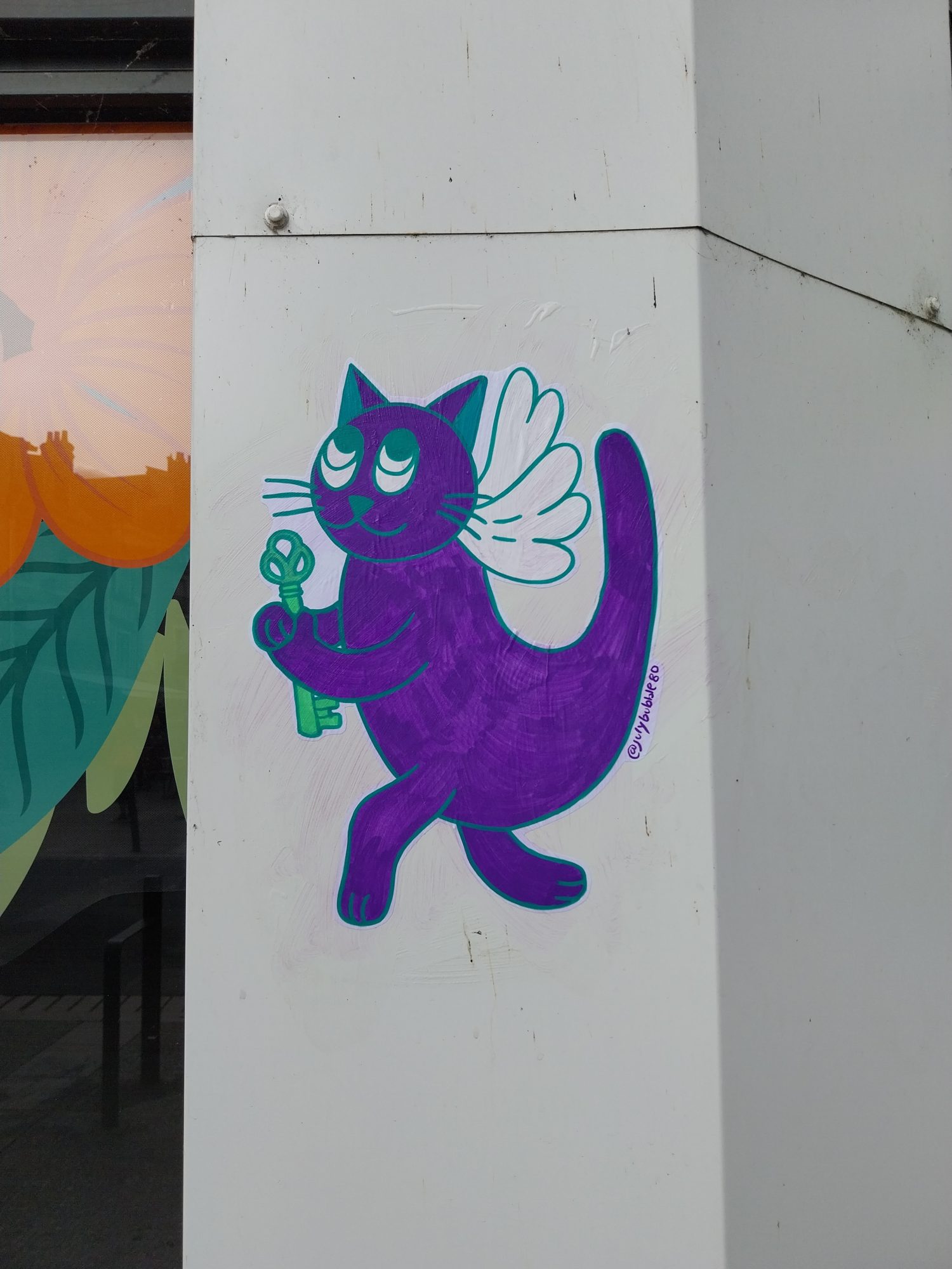 Chat violet ailé tenant une clef — Street art à Blois