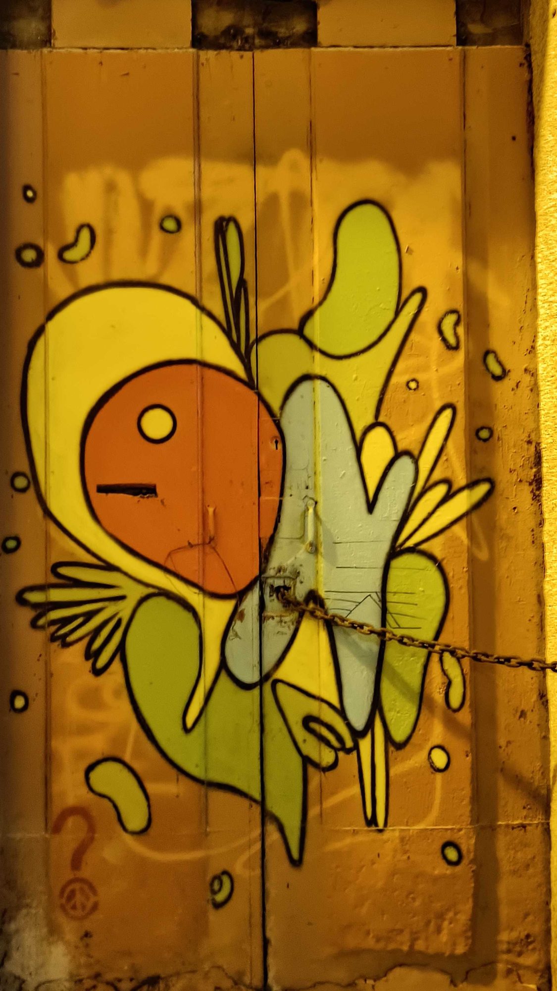 La créature jaune sur la porte — Street art à Porto