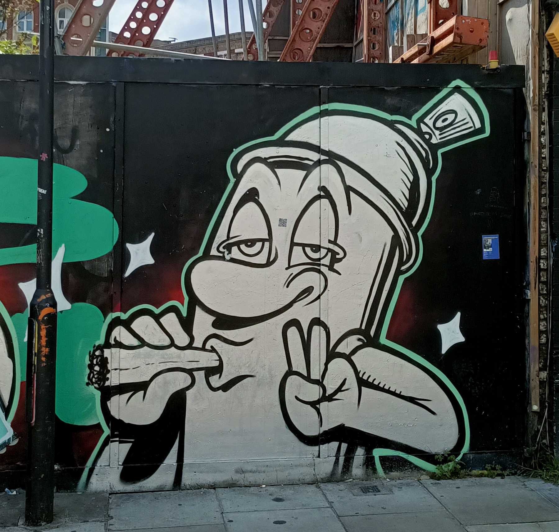 Cartoon spray can flashing a peace sign — Street art in London