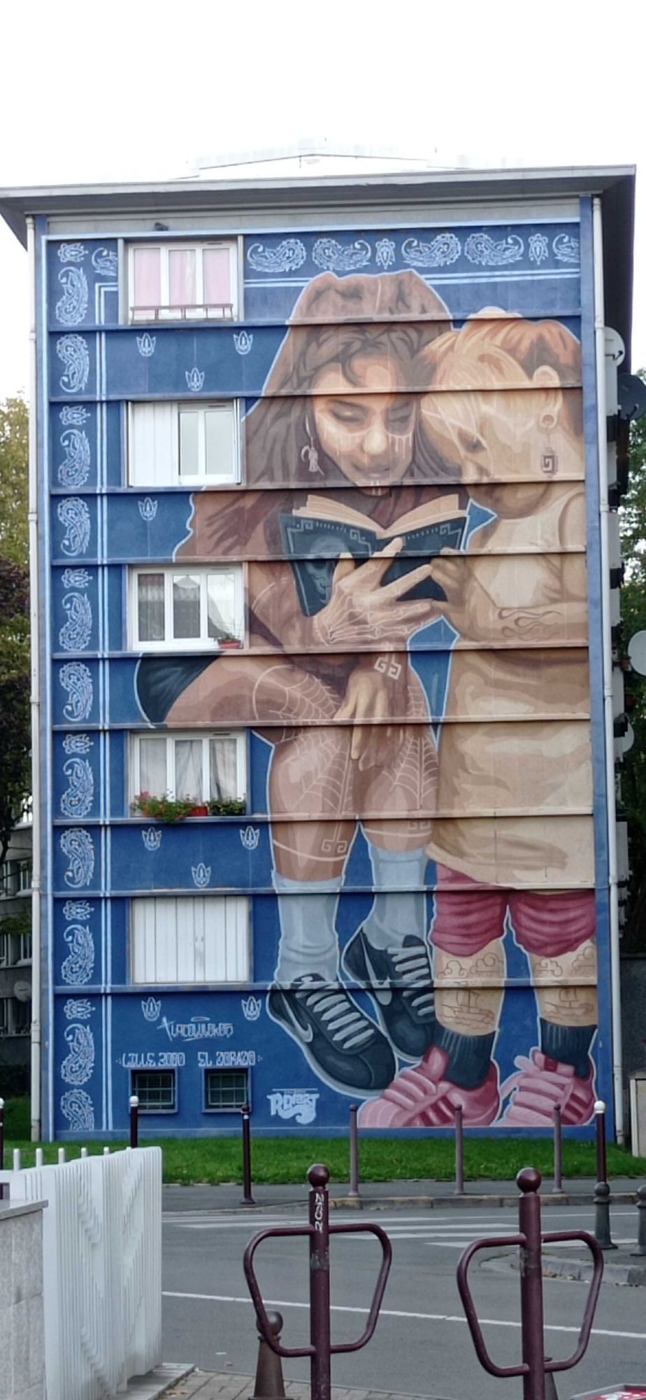 Jeune fille à la lecture sur façade lilloise — Street art à Lille