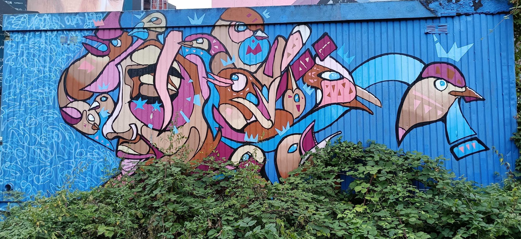 Visages emboîtés et oiseau couronné — Street art à Berlin
