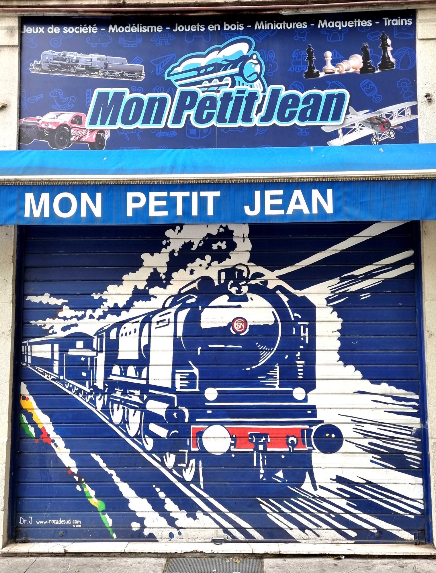 Steam Locomotive on Toy Shop Shutter — Street art in Grenoble
