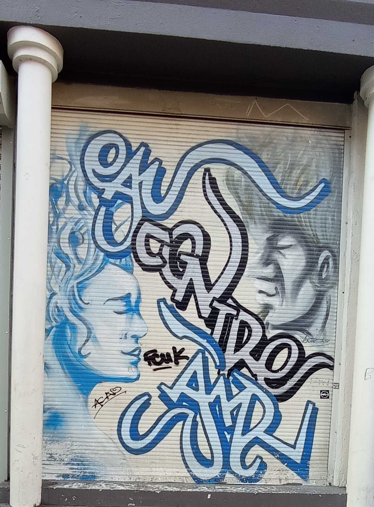 Deux visages sous le lettrage bleu — Street art à Bruxelles