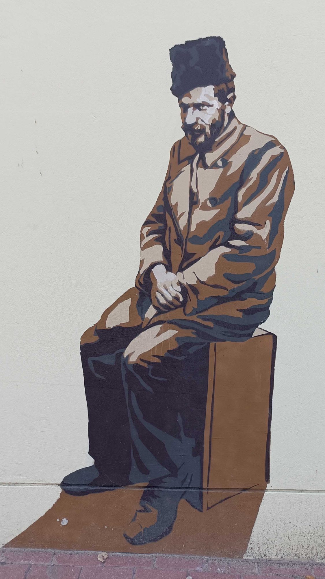 Seated Man in a Fur Hat — Street art in Vilnius