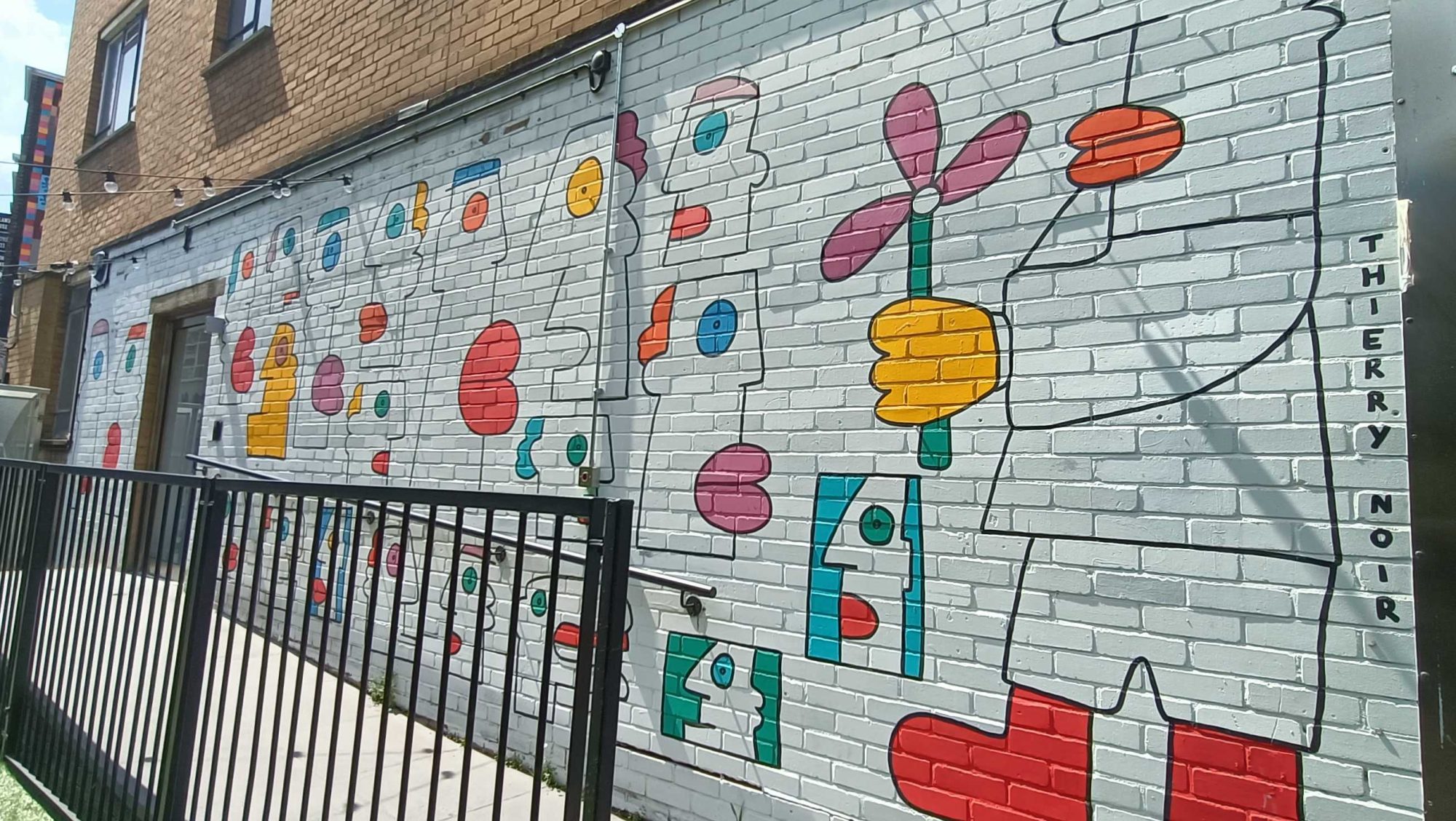 Naive Heads and Flowers by Thierry Noir — Street art by Thierry Noir in London