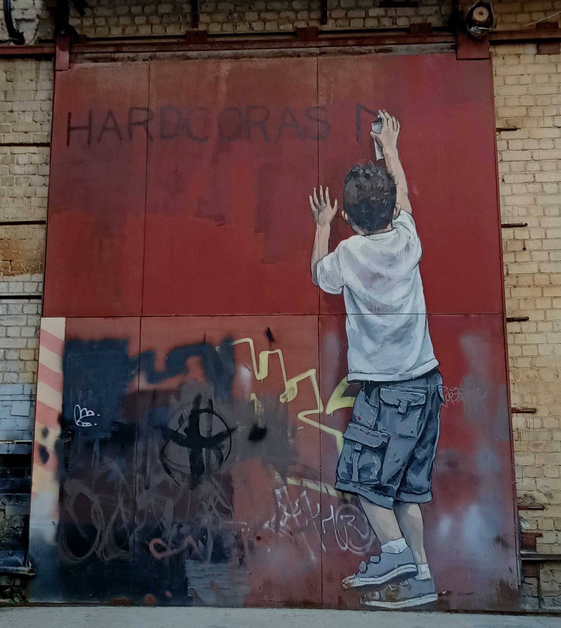 Teenager with hands raised by Zacharevic — Street art by Ernest Zacharevic in Vilnius