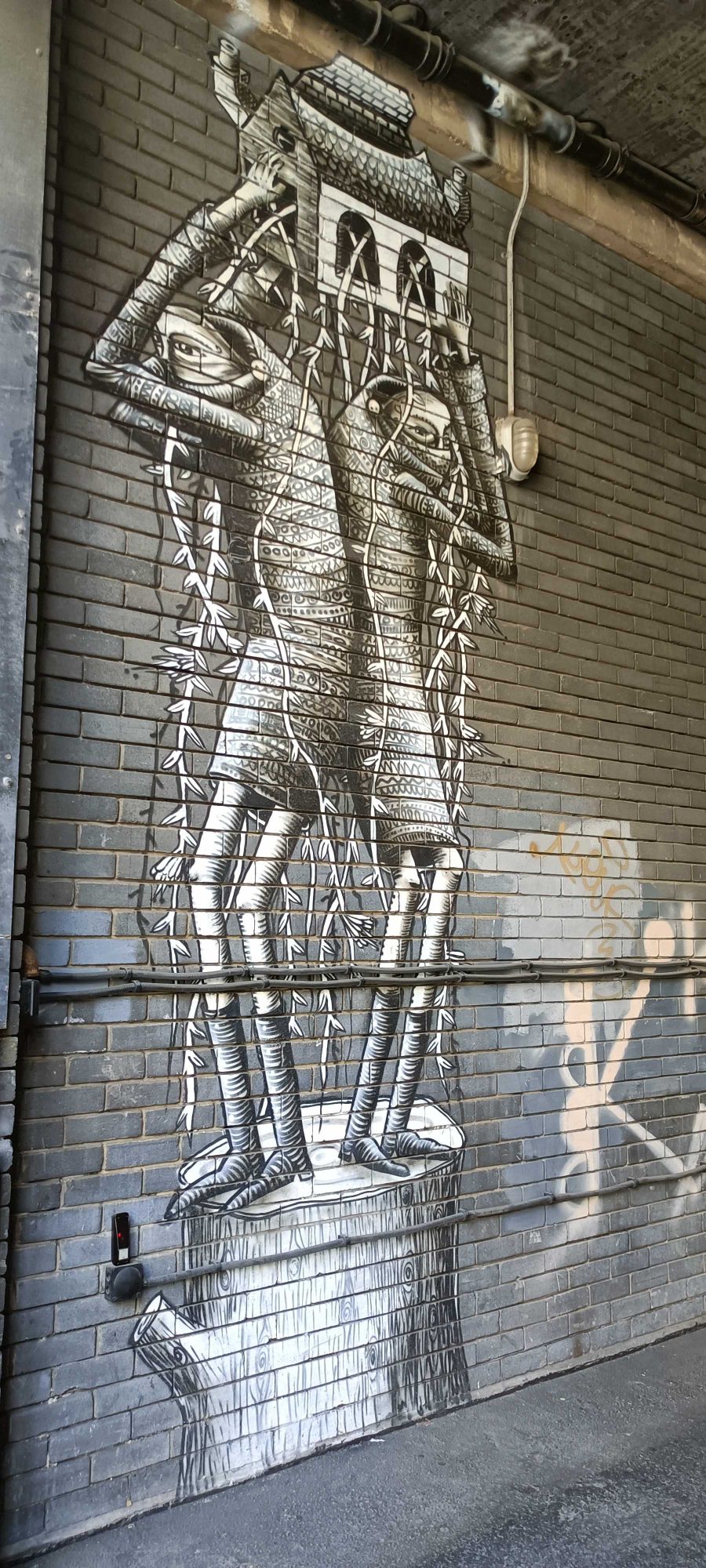 Figure crowned with a small building — Street art by PHLEGM in London