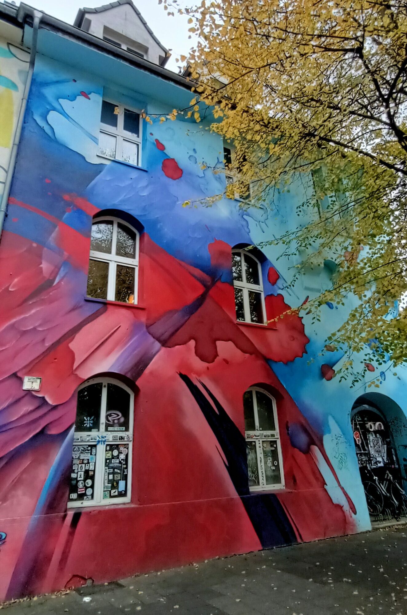 Gestes rouges et bleus sur la façade — Street art à Düsseldorf