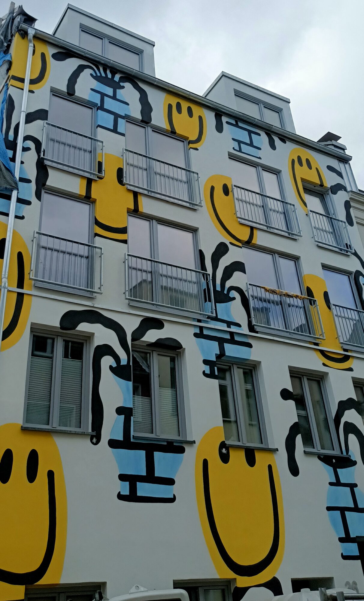 Smileys, the facade of yellow smiles — Street art by Marcel Kreuzer in Köln