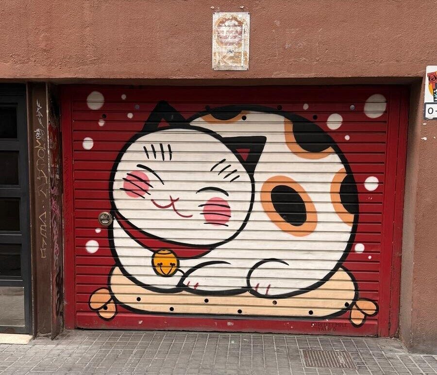 Chat porte-bonheur sur rideau rouge — Street art à Barcelona