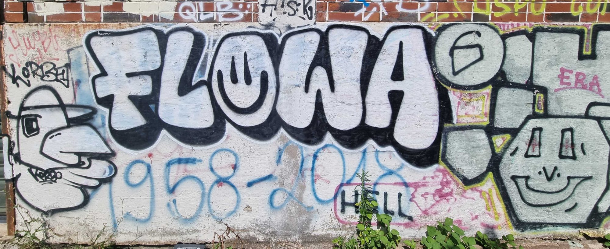 Tag 'Flowa' et personnages souriants — Street art à Strasbourg