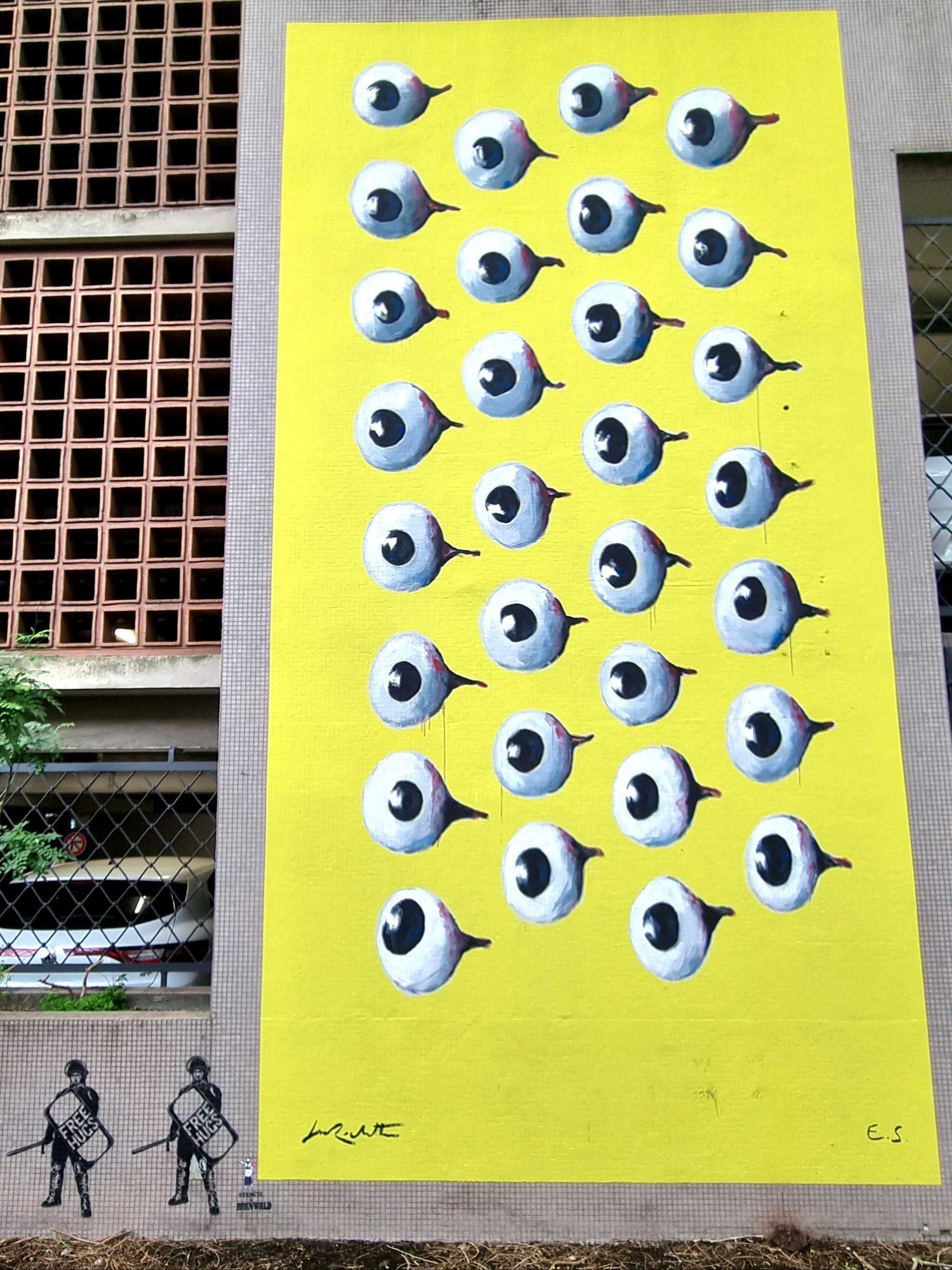 The Wall of Eyes on Yellow — Street art by Jean-Marc Rochette in Grenoble