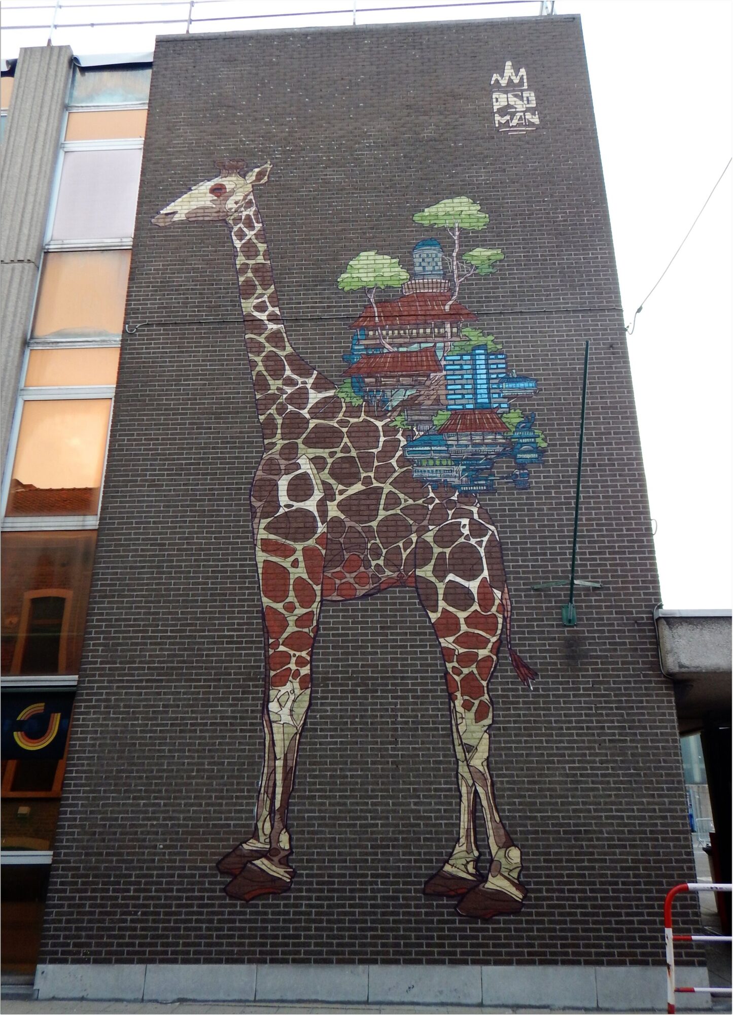The giraffe carrying a city — Street art by Psoman in Liège