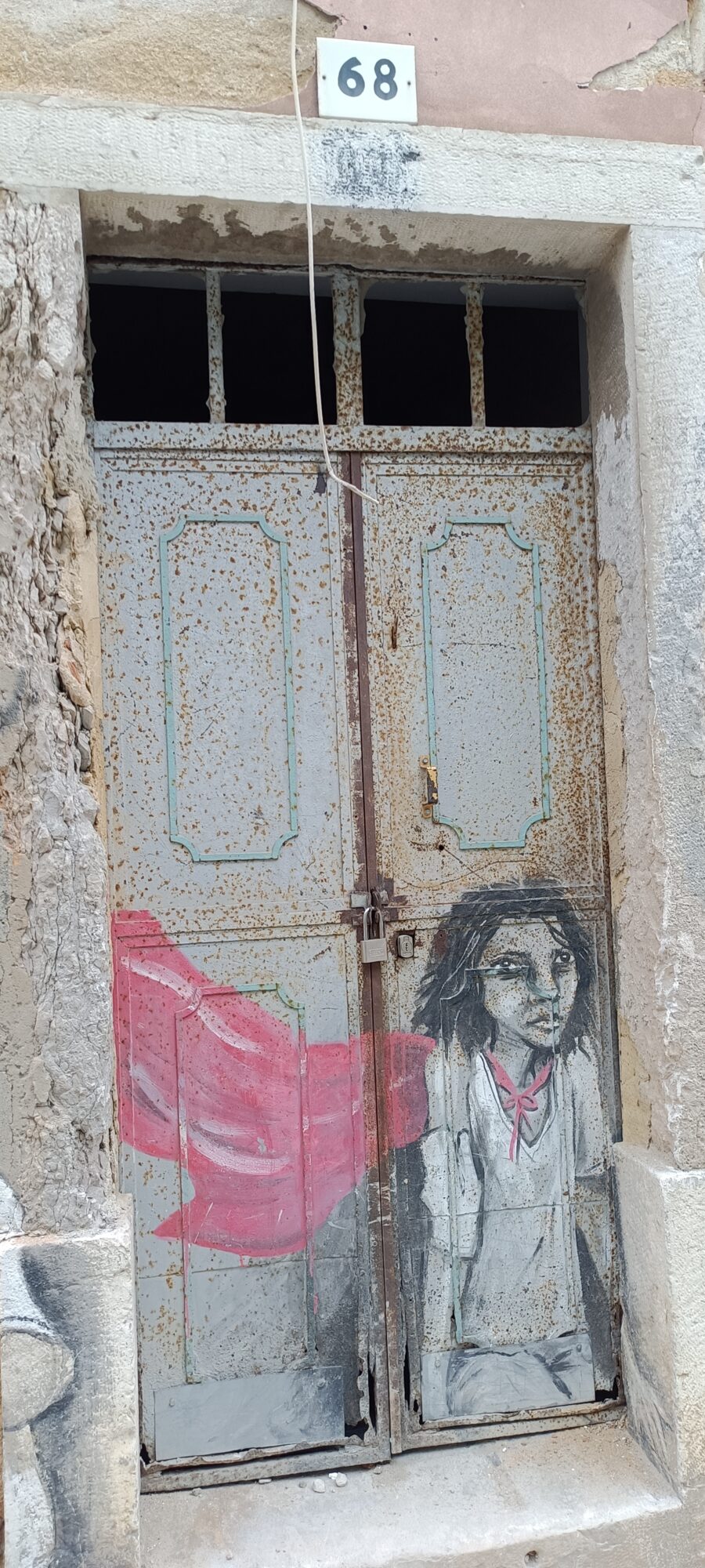 Girl with a Red Flag on Door 68 — Street art by Rosarlette Meirelles in Almada