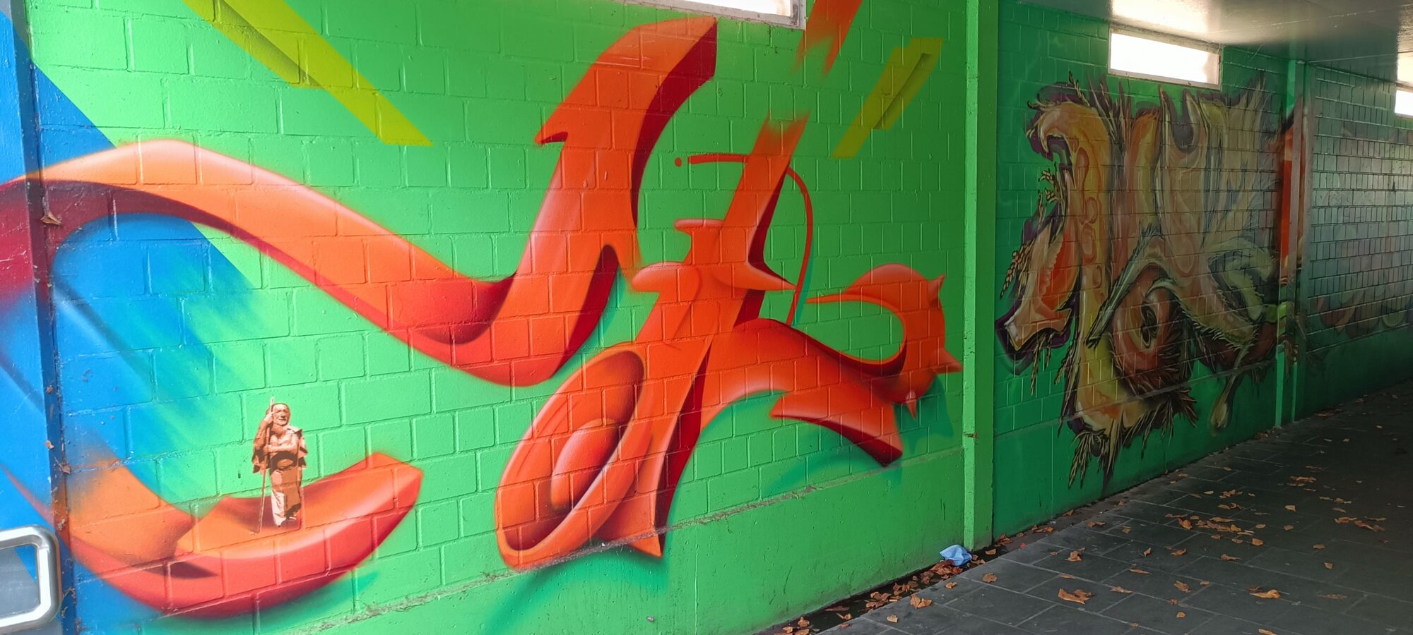 Orange lettering and a small Buddha — Street art by NEANDERARTgroup in Erkrath