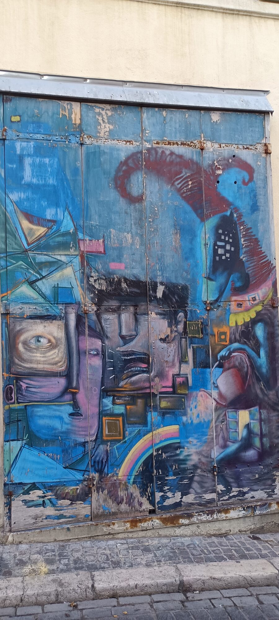 Interlocking Faces on a Blue Door — Street art in Marseille