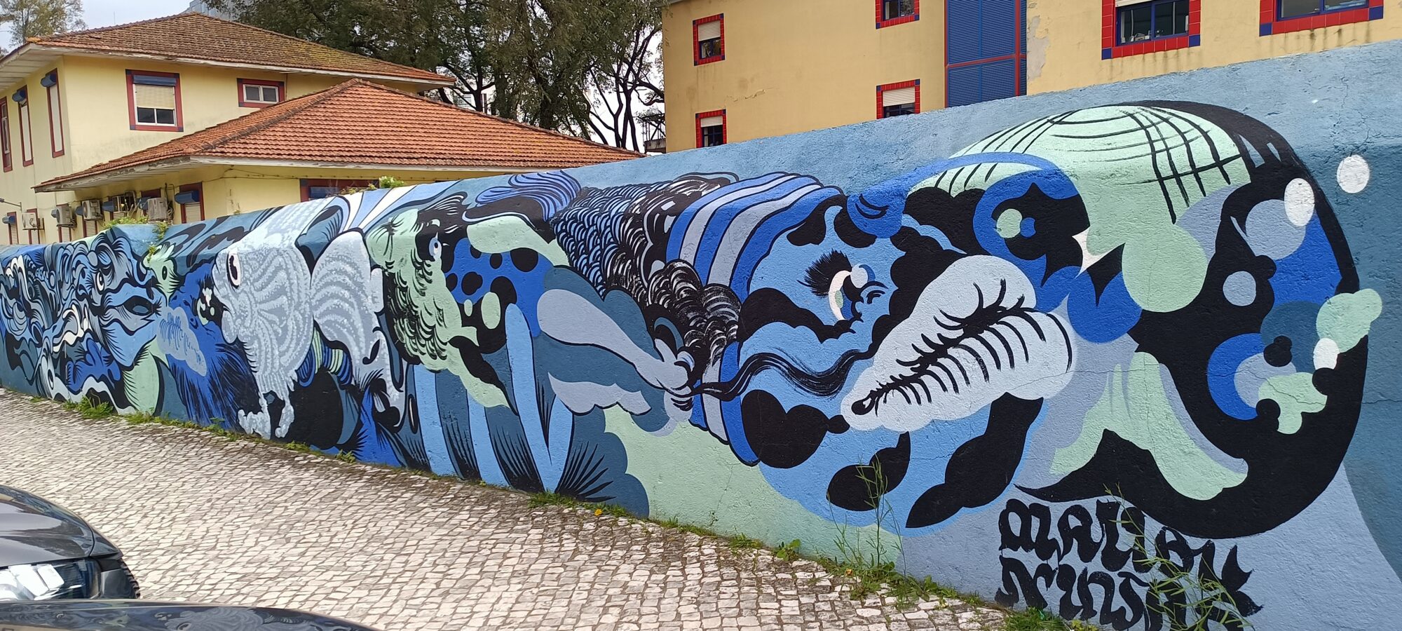 Vague de visages en noir et menthe — Street art à Lisboa