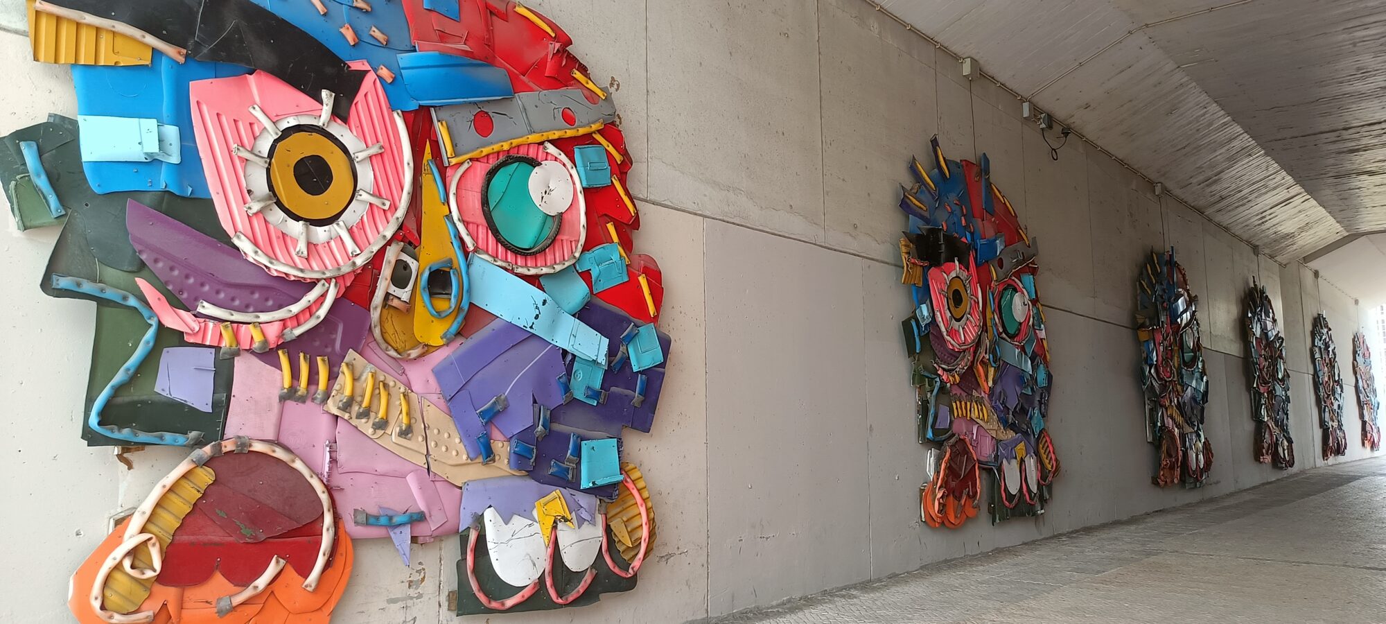 Enfilade de masques sous le passage couvert — Street art de Bordalo II à Lisboa