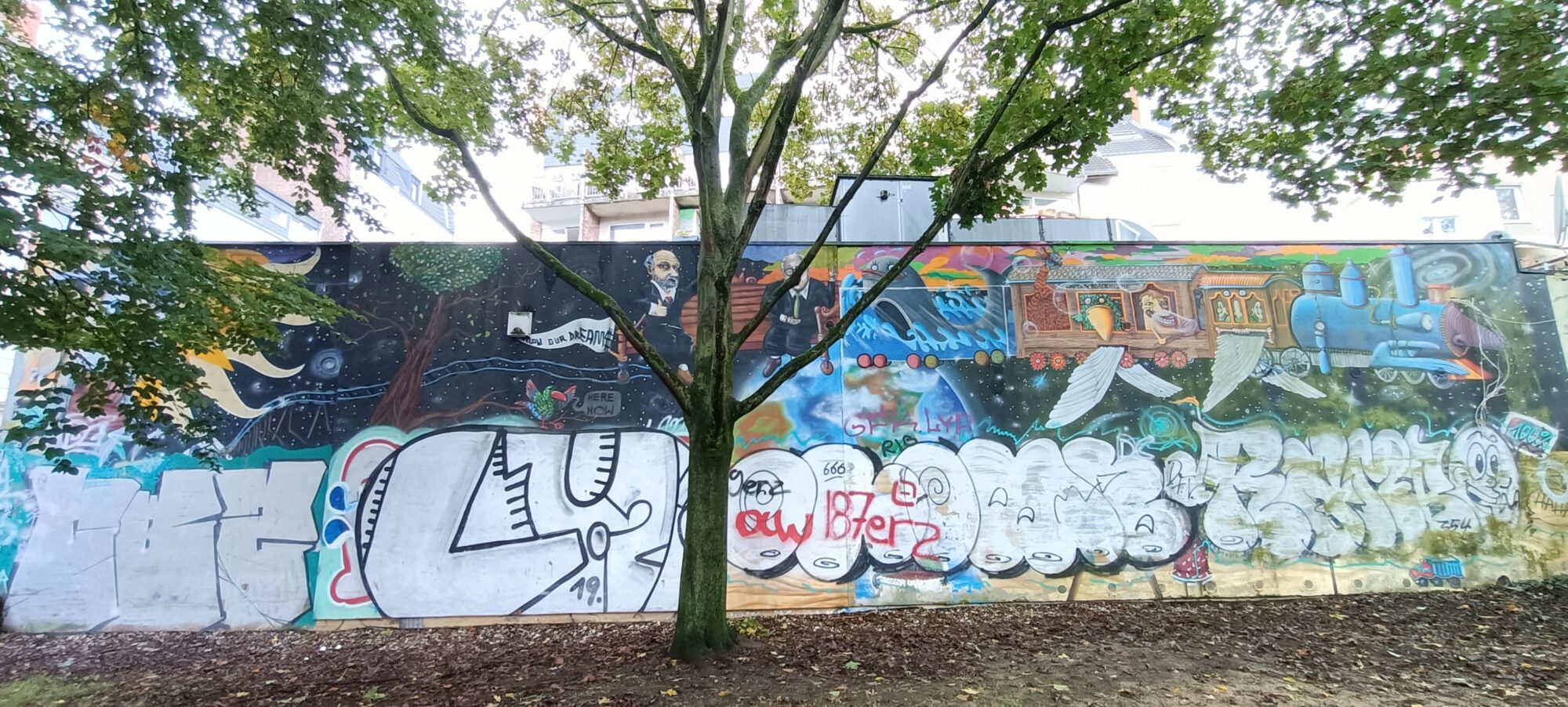 Locomotive and fairground caravan — Street art in Köln