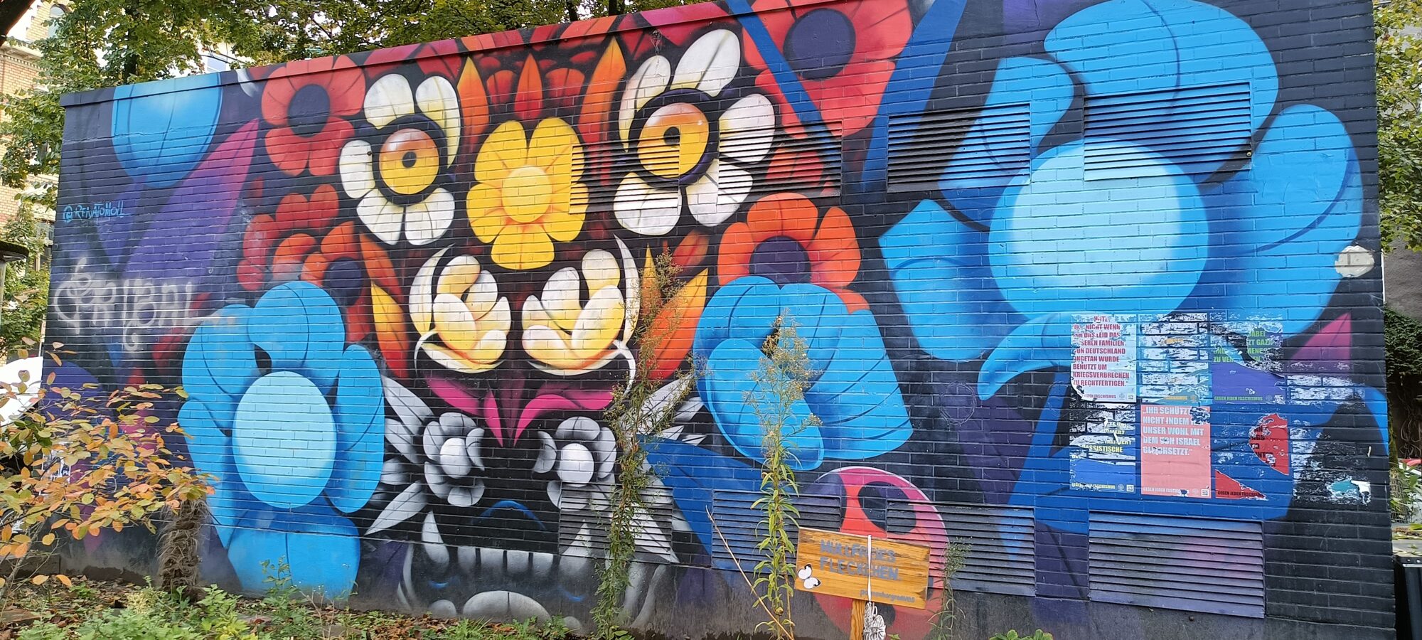Masque de fleurs sur mur noir — Street art à Köln