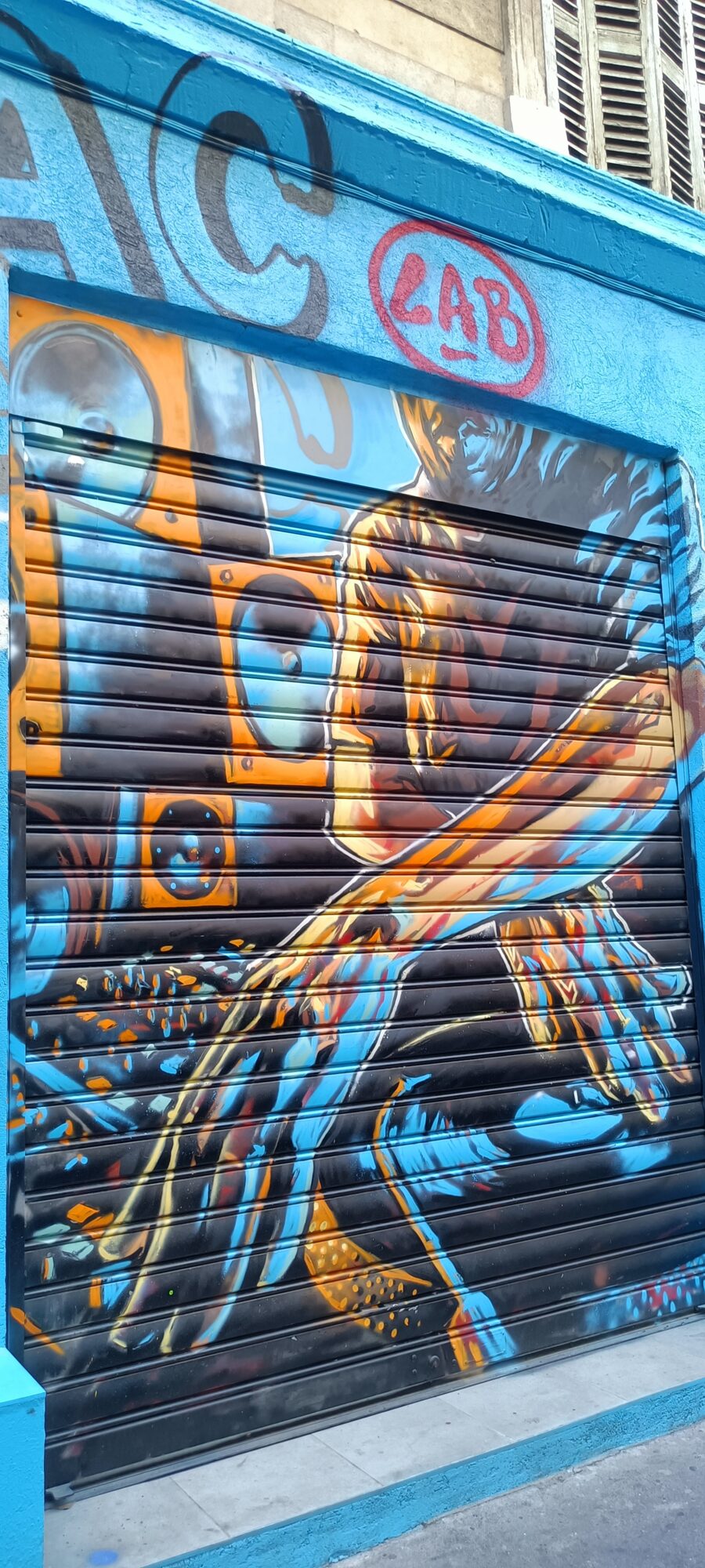 Guitarist and amps on a blue shutter — Street art in Marseille