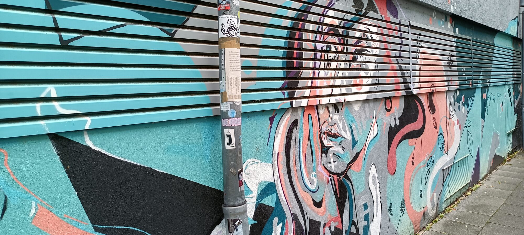 Visage aux rubans corail et turquoise — Street art à Köln