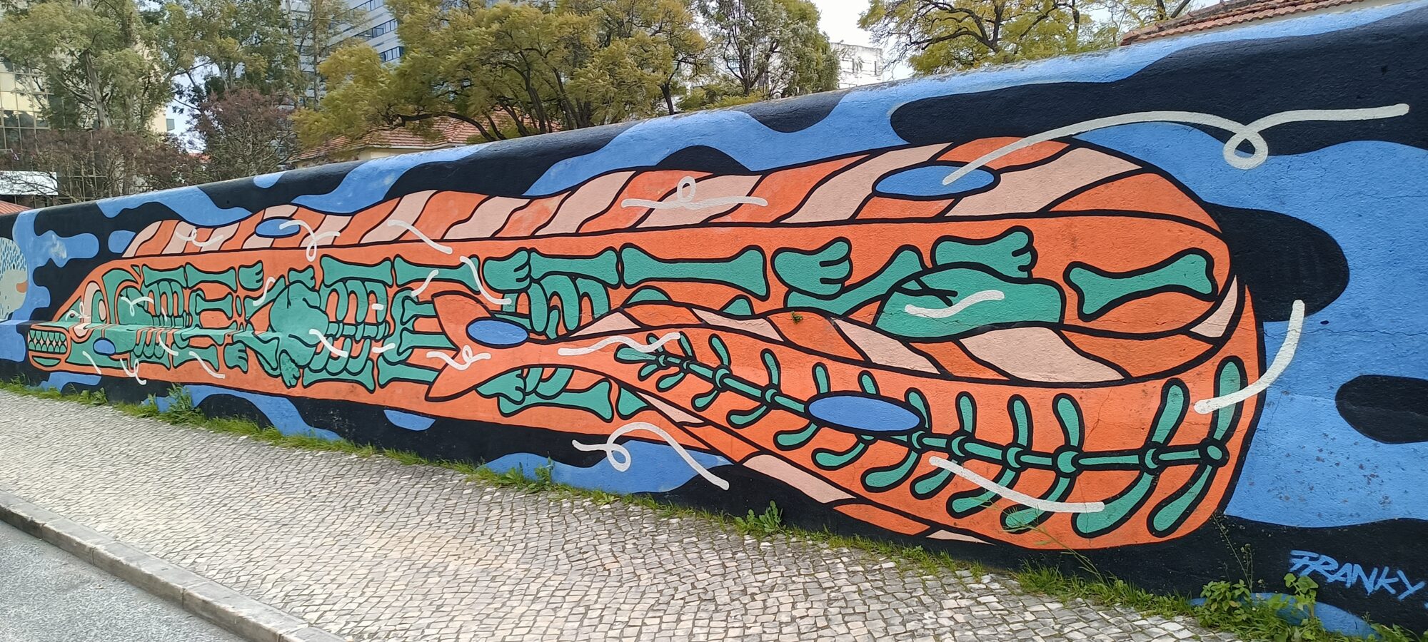 Poisson squelette orange — Street art de Mariana Rio à Lisboa