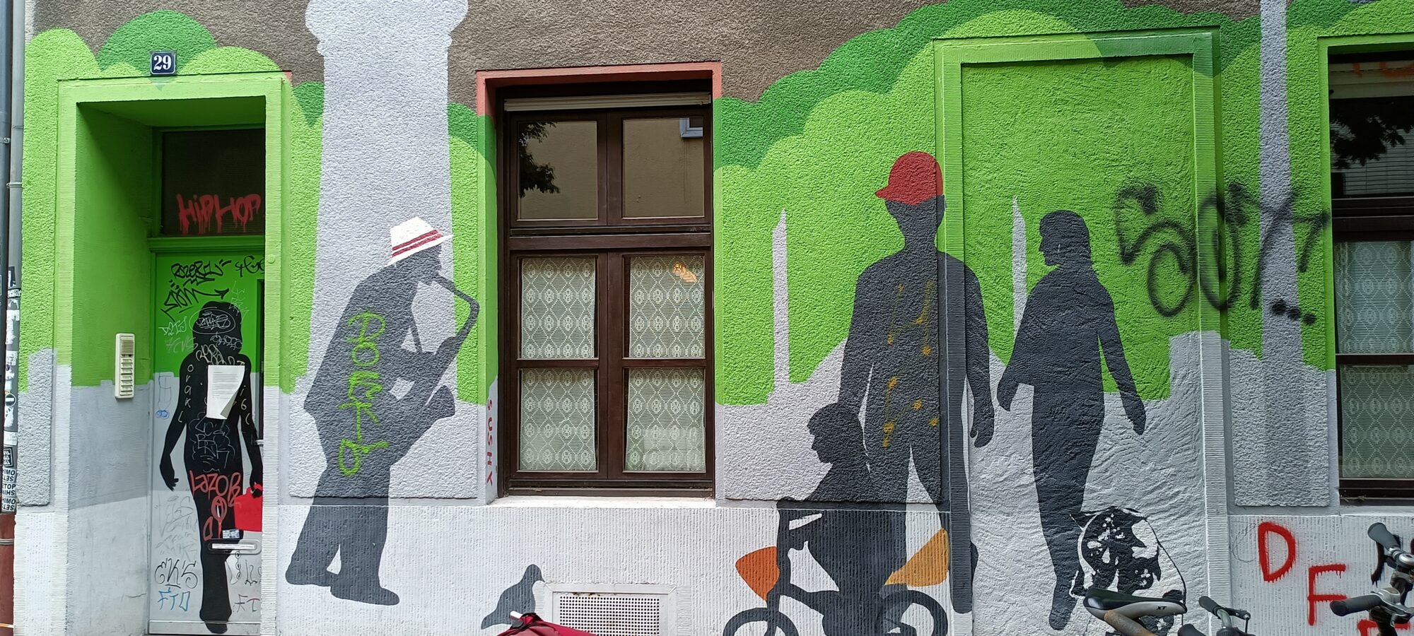 Silhouettes of the saxophonist and passers-by — Street art in Köln